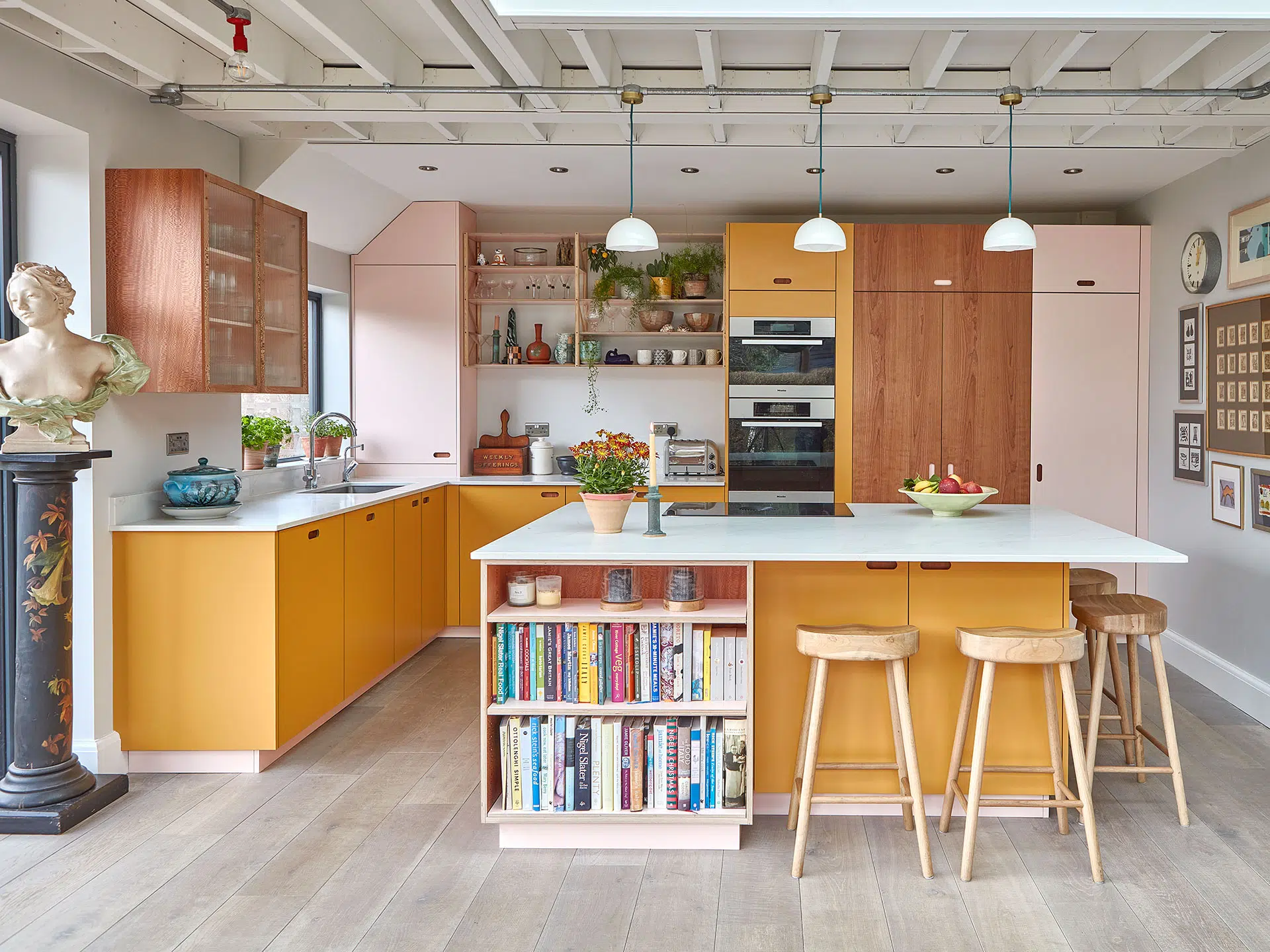 A hand crafted wooden Pluck Prep Table with a Capolavoro quartzite natural stone worktop on a patterned rug, with fluted glass cabinets, and London Plane wood cupboards and drawers.
