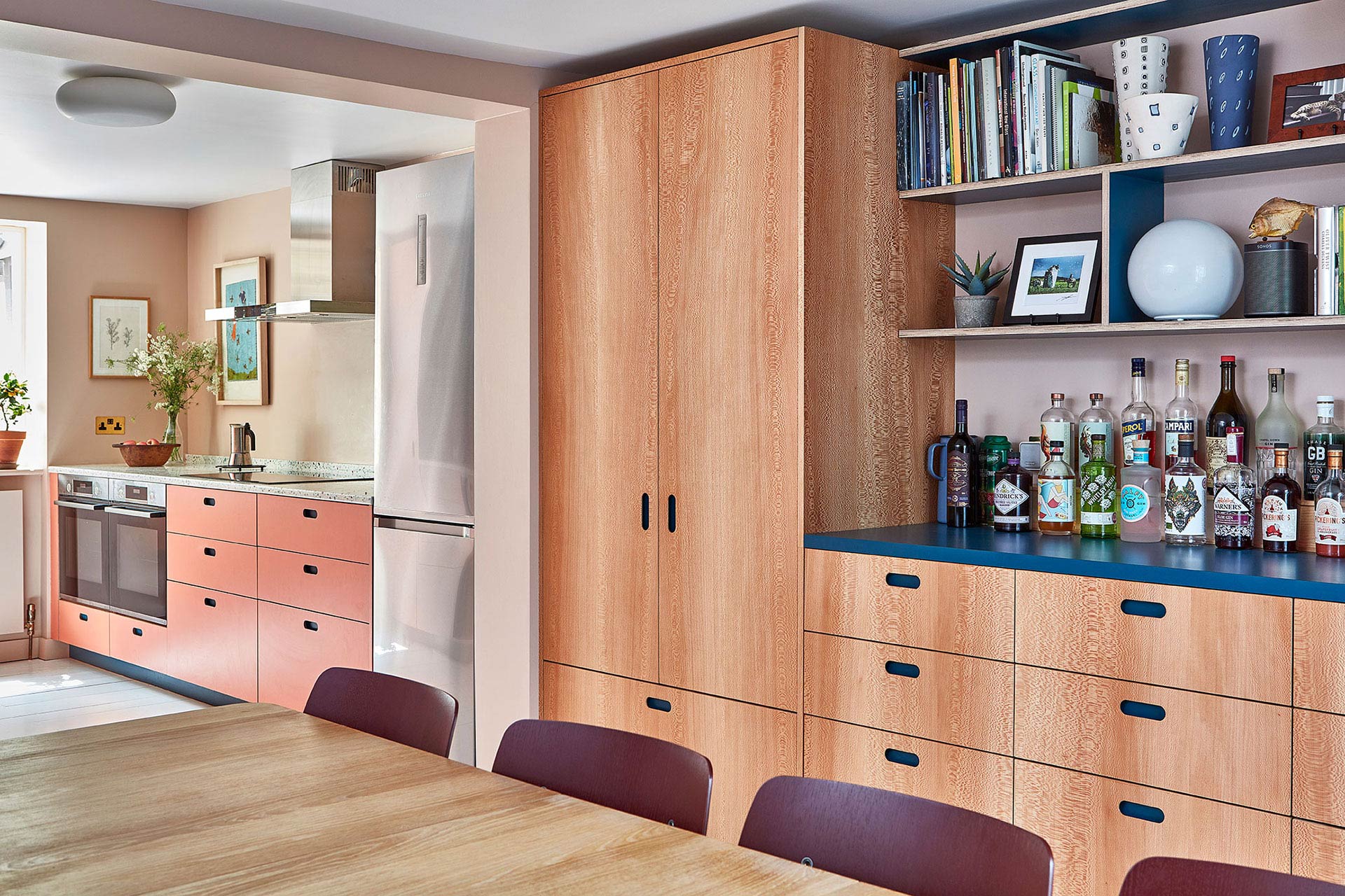 Blue, coral pink and wood Pluck cabinetry with glass terrazzo in an Islington townhouse kitchen.