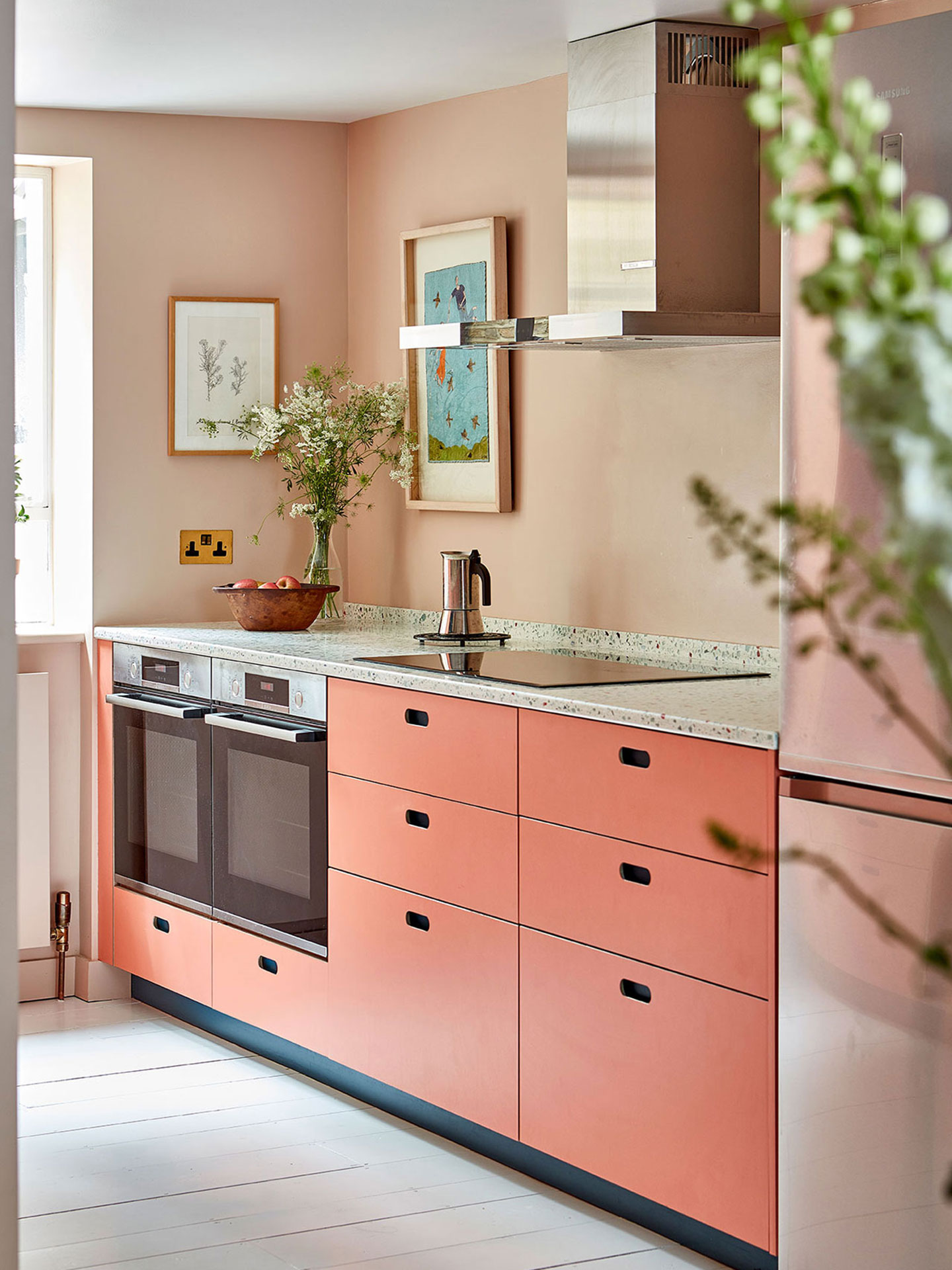 Coral pink, blue and wood galley kitchen with terrazzo in Islington.