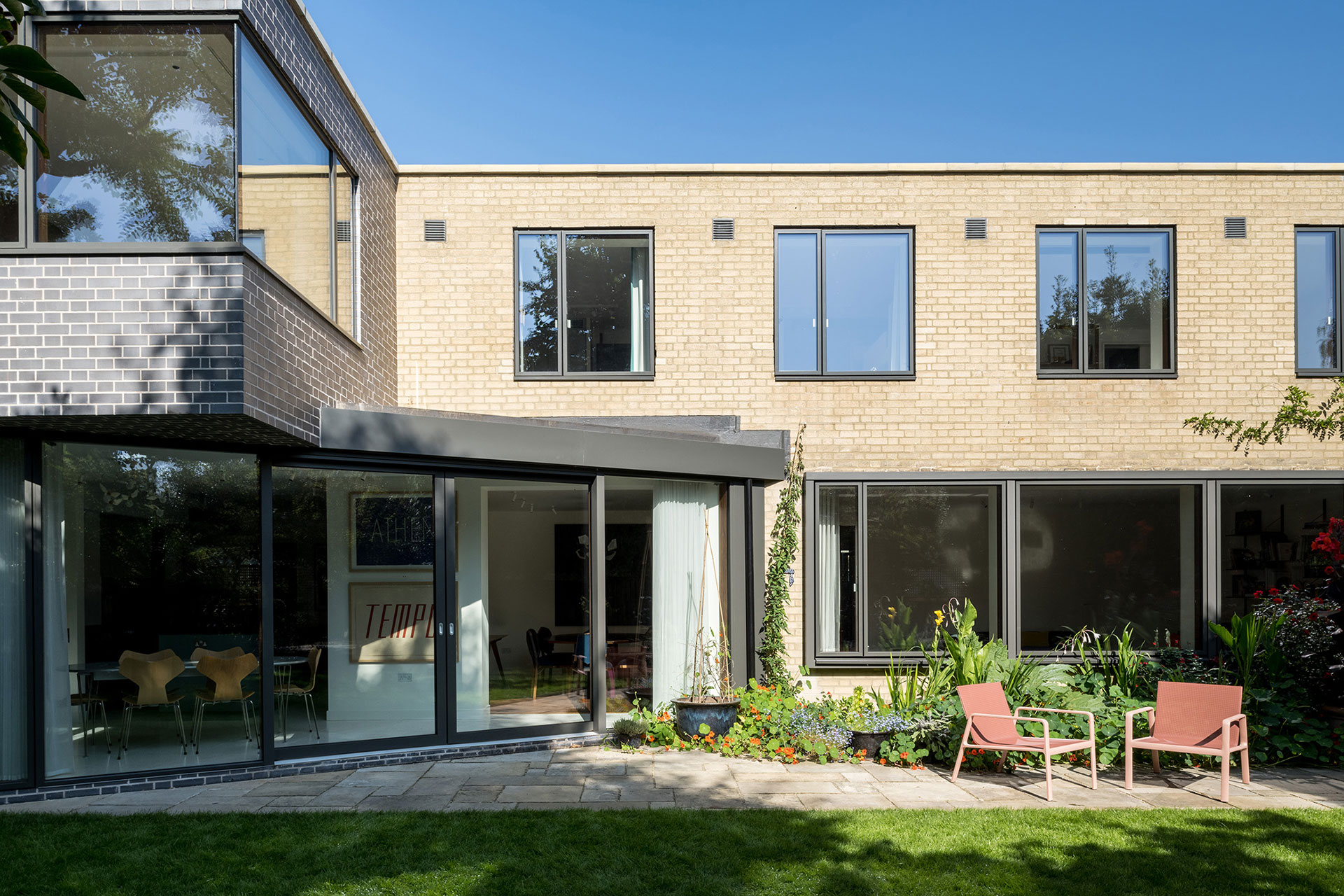 Cherry wood and green kitchen with stainless steel worktops in a mid-century London home.