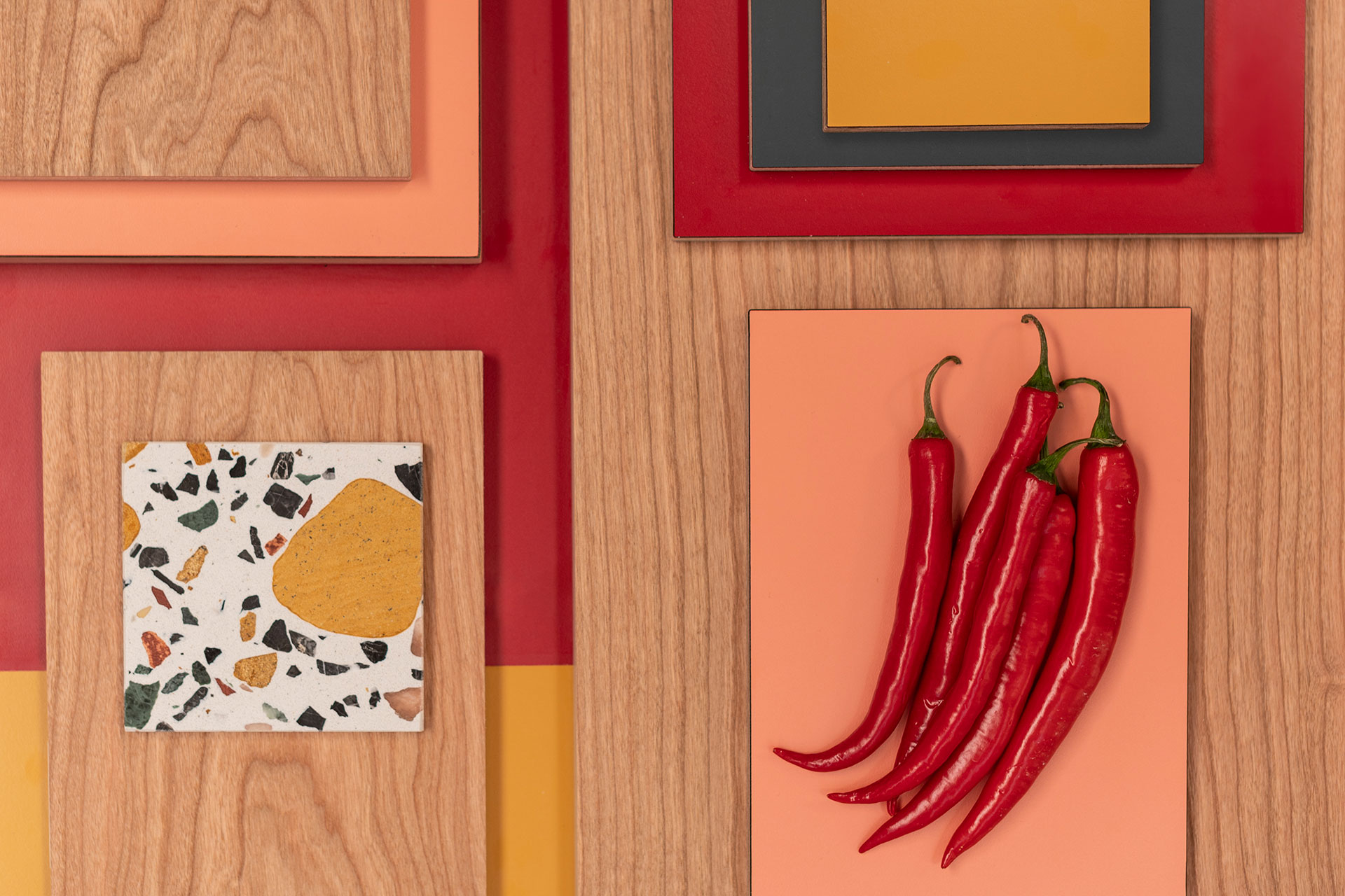 Bright red, mustard yellow and coral pink colour kitchen inspiration with warm pink toned Cherry wood, terrazzo and chillis.