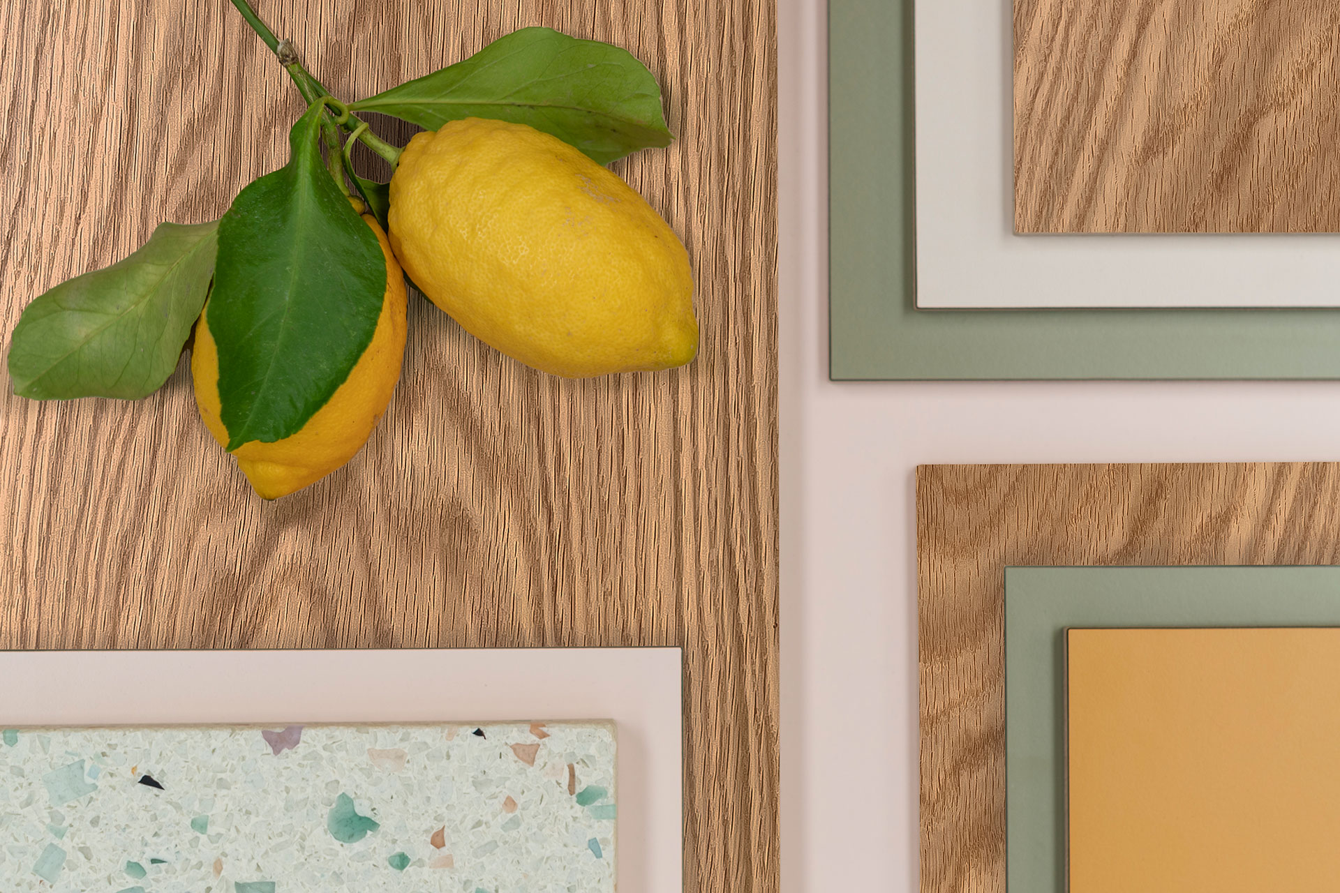 Oak wood with soft green, pale pink, mustard yellow, beige, terrrazzo and leafy lemons providing kitchen colour inspiration.