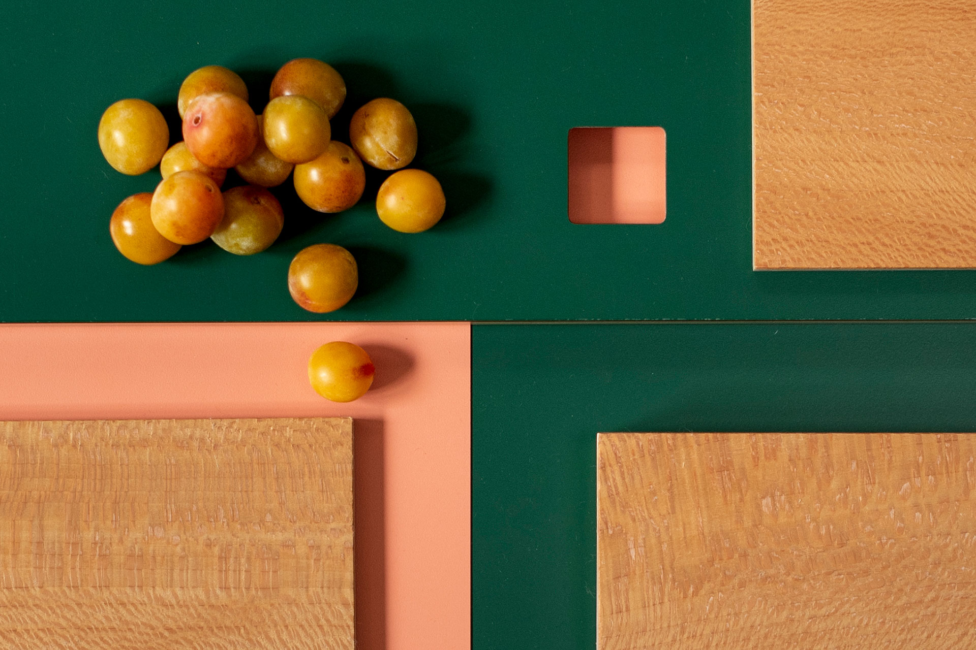 Vivid coral pink and bottle green kitchen colour inspiration with beautiful flecked London Plane wood and mirabelle plums.