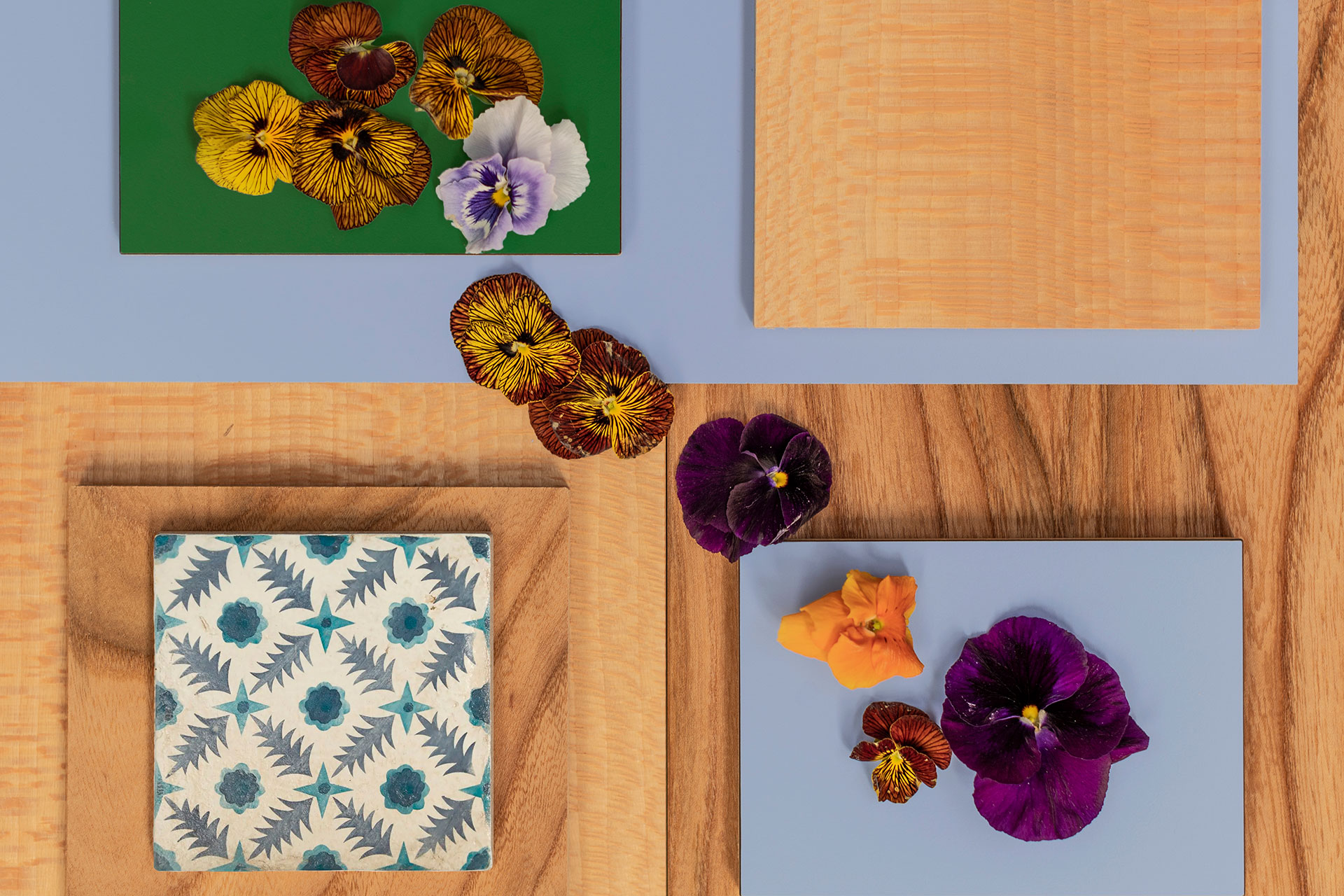 Inspiring kitchen colours including chalky blue, forest green, Elm and London Plane wood, pansy flowers and patterned tile.