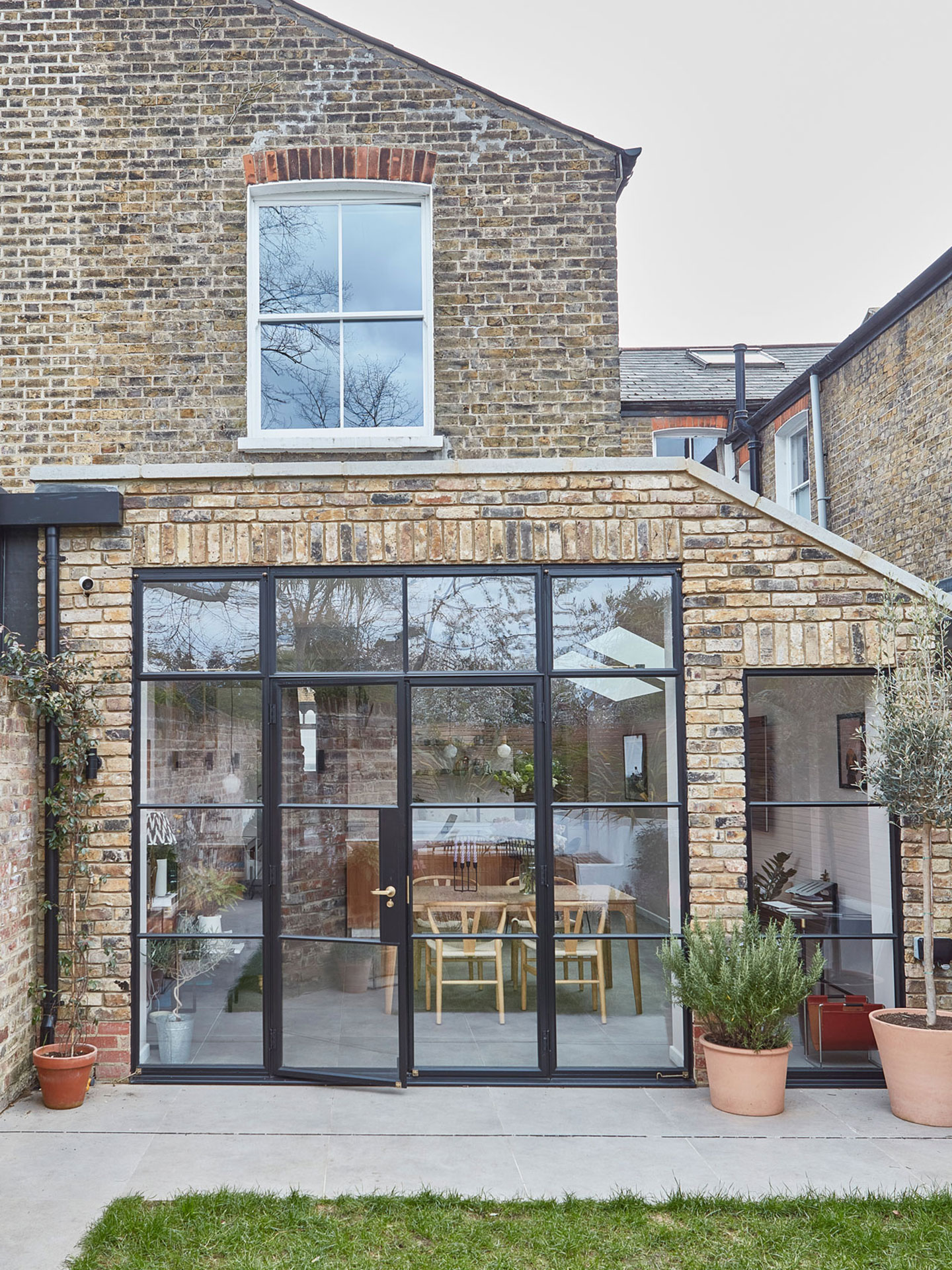Exterior of a recently extended Victorian terrace with exposed brickwork and crittall glazing.