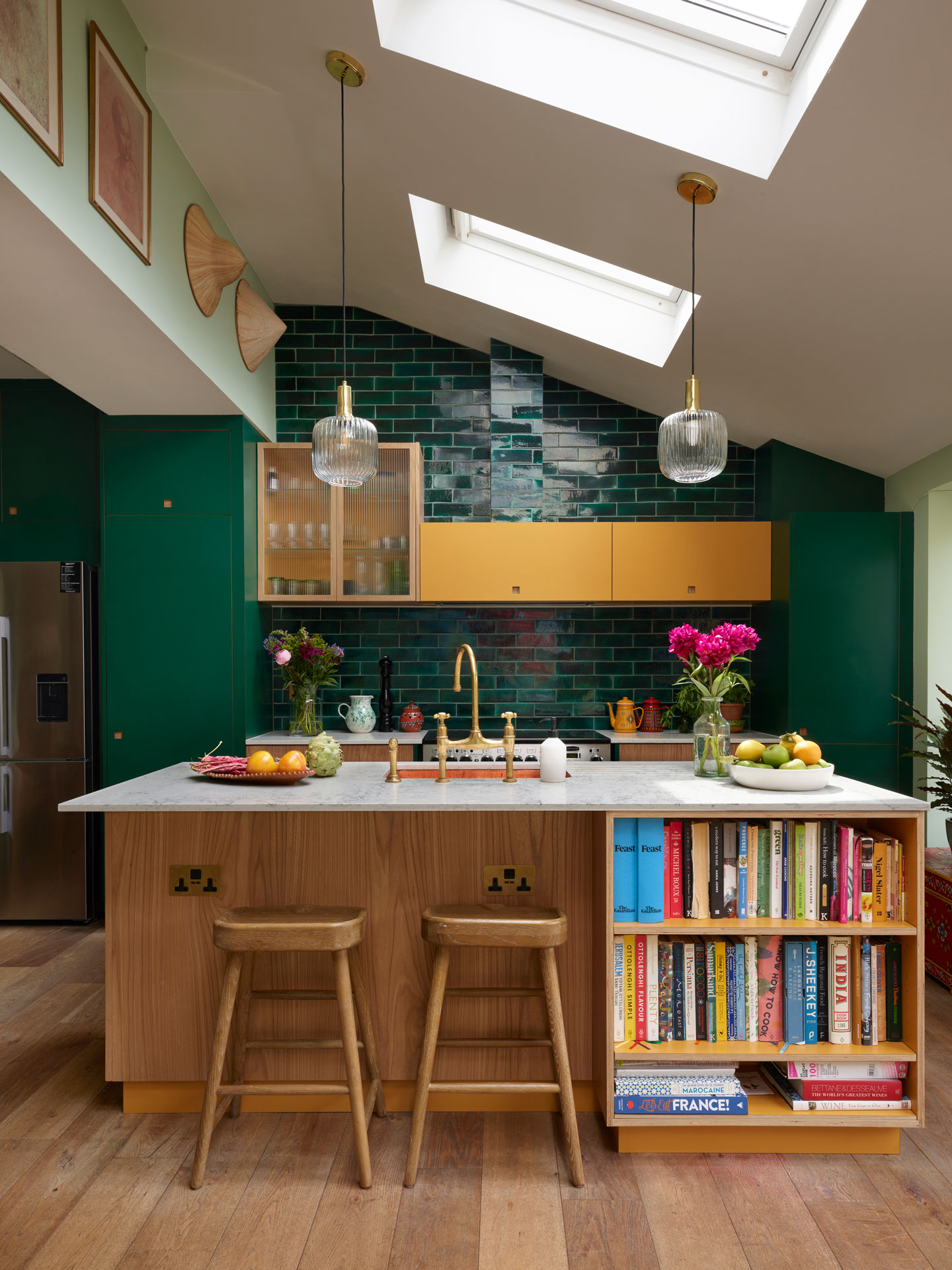 Kitchen home to an artist including dark green, Elm wood and mustard yellow cabinets, glossy tiles and pale palm green walls.