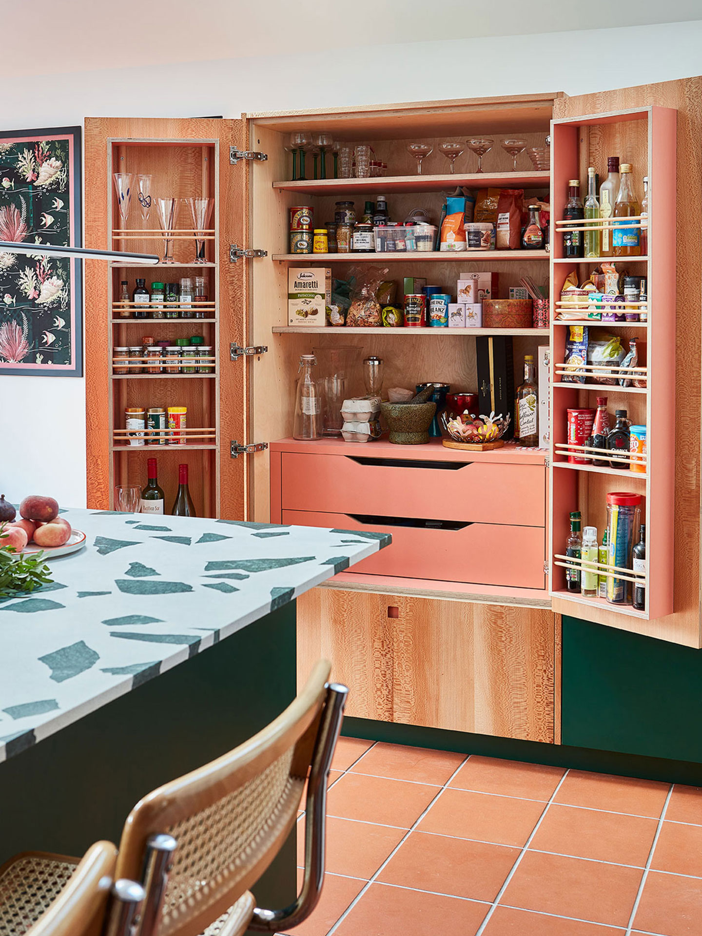 Pluck's London Plane larder cupboard, terracotta floor tiles and a central island with a bold terrazzo worktop.