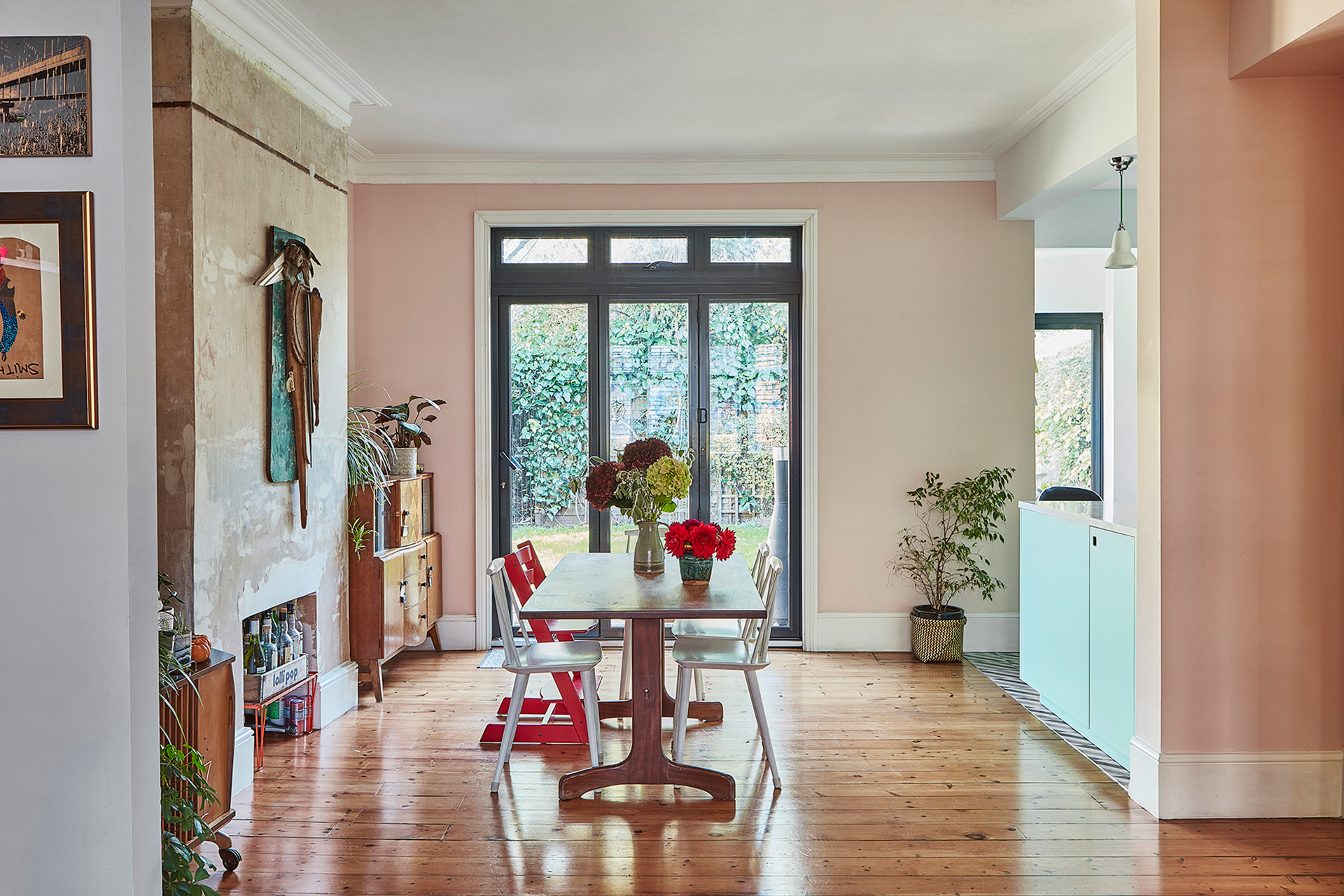 Inspiring bright blue kitchen with patterned floor tiles and a dining area with wooden flooring.