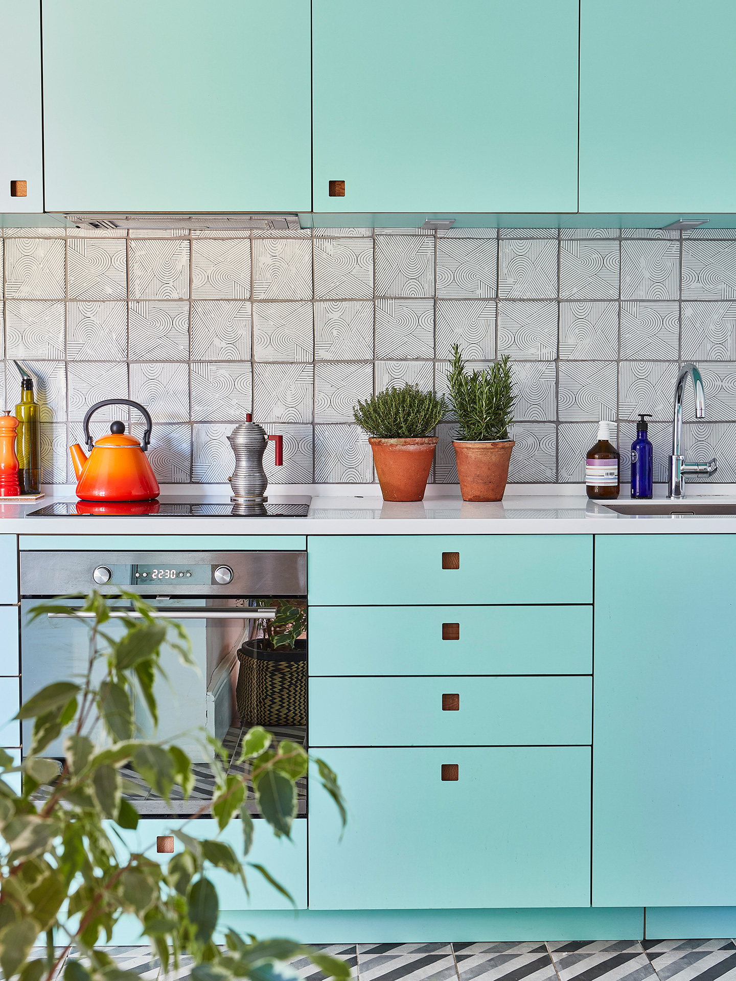 Inspiring bright blue kitchen with patterned floor tiles.