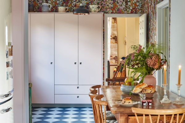 Pretty cottage kitchen in Epping Forest with soft pink cabinets, floral House of Hackney wallpaper and checkerboard floor.