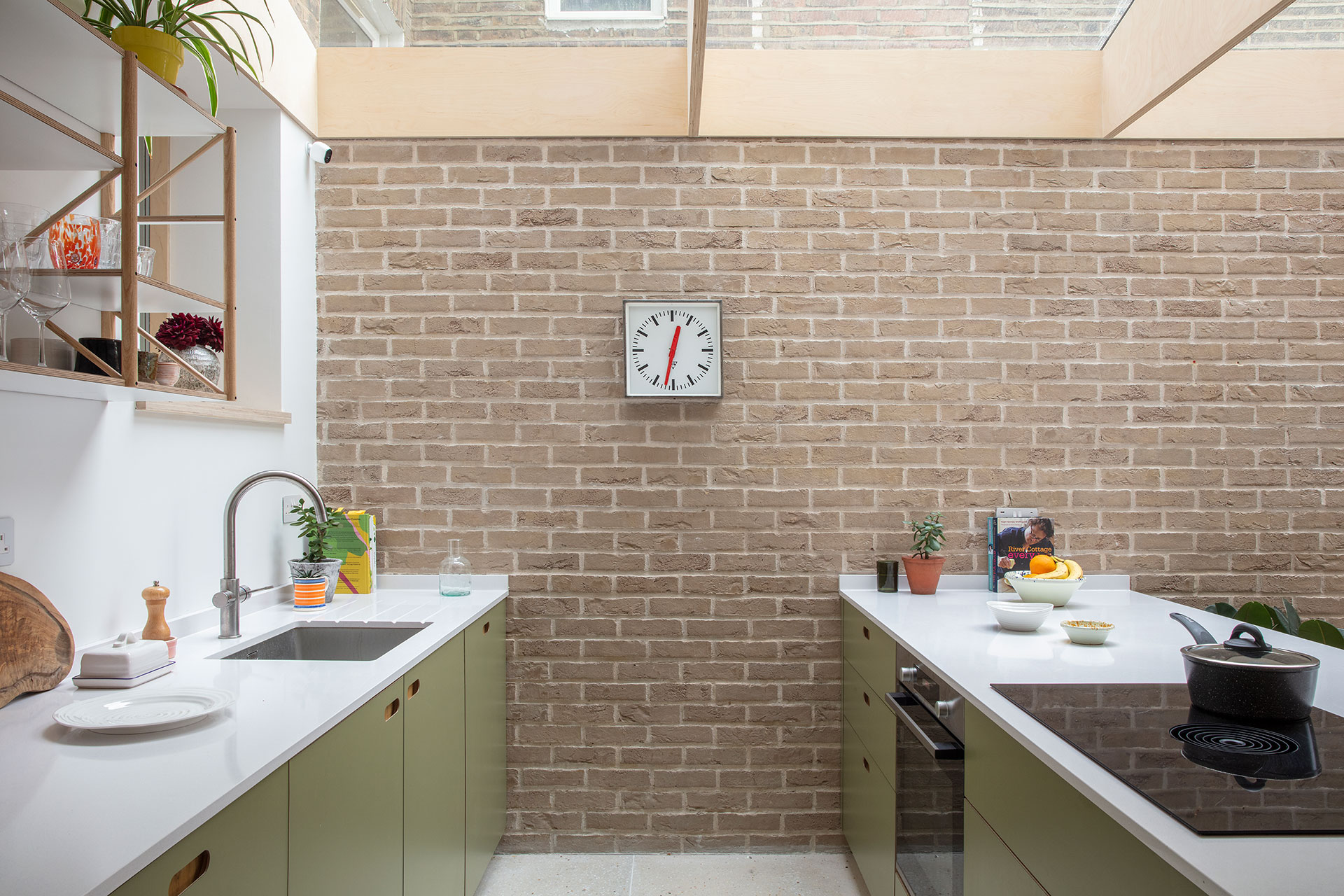 Wood, white and green kitchen with picture gallery shelving and a dining table.