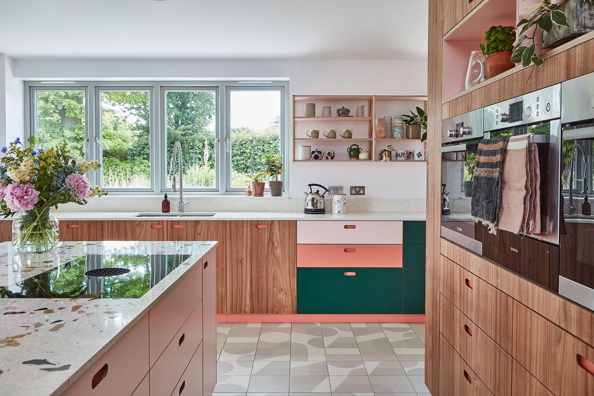 Colourful pink, green and Elm wood kitchen in an eco house in Kent.