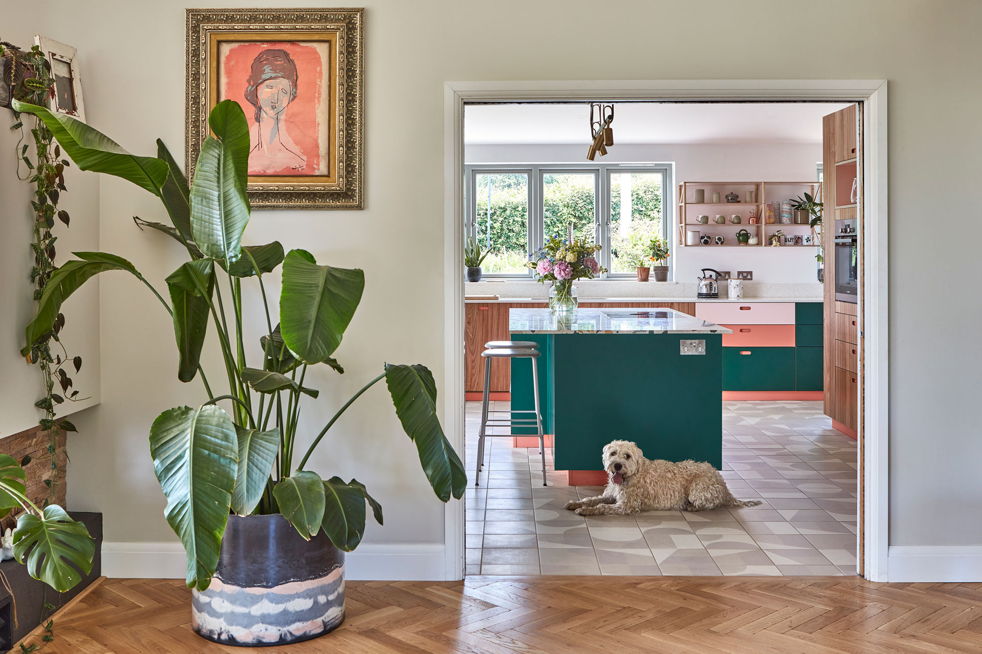 Eco house in Kent with colourful Pluck kitchen cabinets including green, pink, Elm wood and a terrazzo topped island.