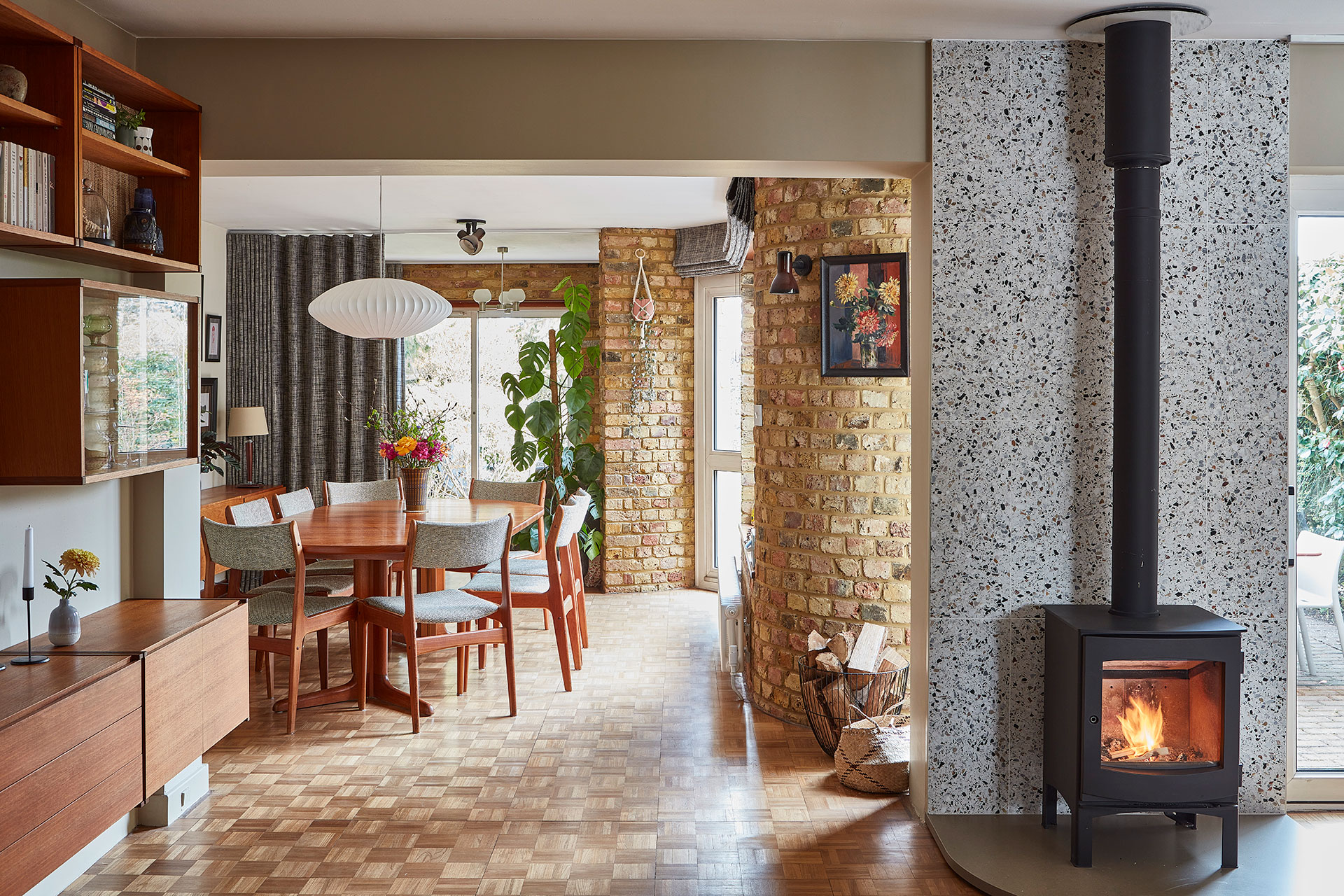 Modernist dining room with parquet flooring, curved walls and mid century furniture.