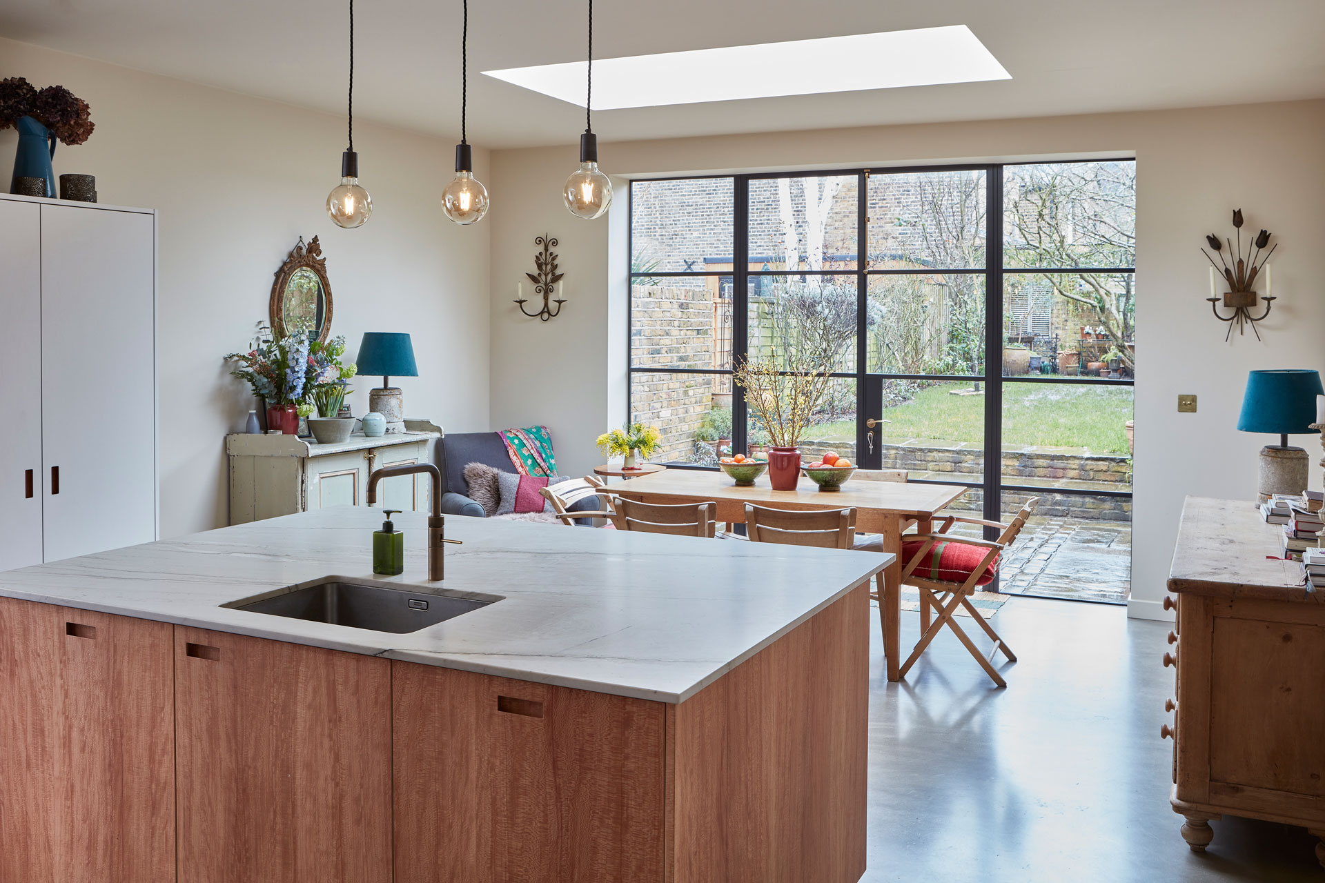 Calming neutral kitchen including London Plane wood and white handmade cabinetry topped with natural stone.