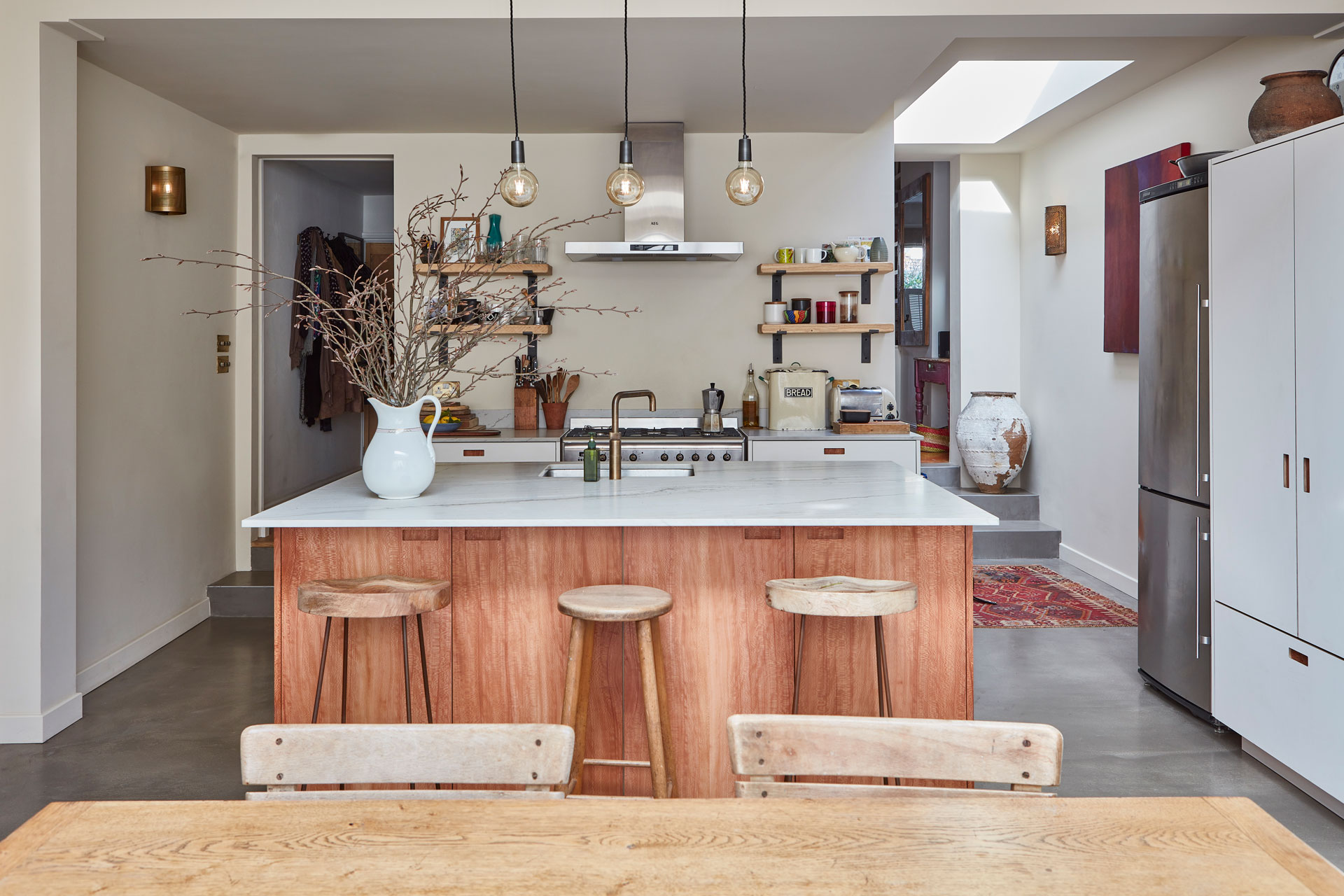 Neutral wood and white Pluck kitchen topped with natural stone.