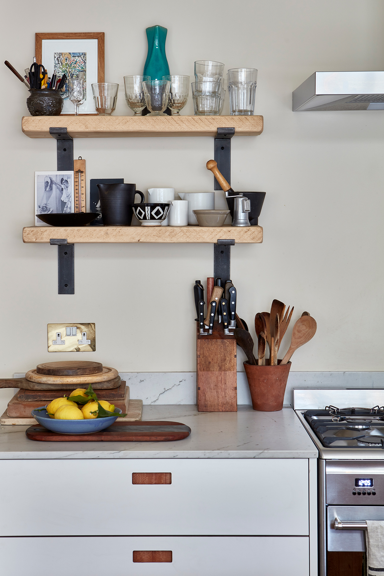 Neutral wood and white Pluck kitchen topped with natural stone and wood shelves.