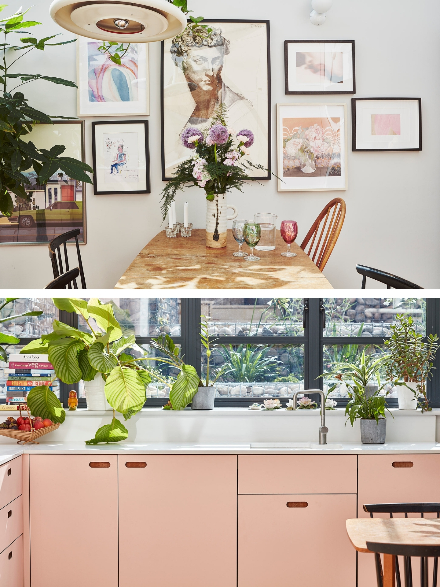 A bright kitchen with powder pink cabinets, potted plants, a vintage dining table and a gallery wall of prints and paintings.