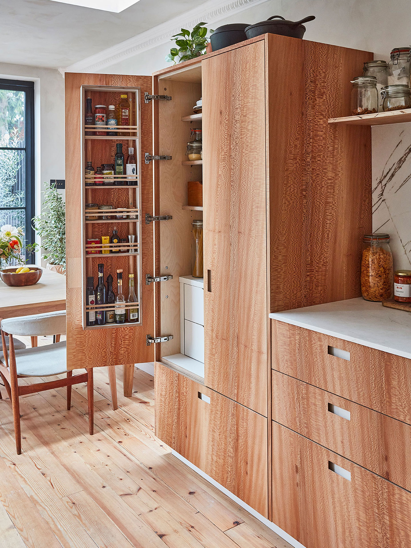 Calming neutral kitchen including London Plane wood and white handmade cabinetry topped with natural stone.