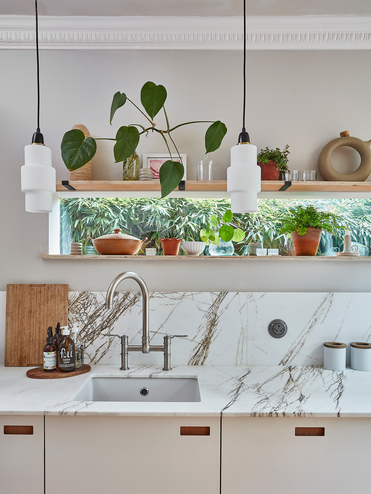 Calming neutral kitchen including London Plane wood and white handmade cabinetry topped with natural stone.