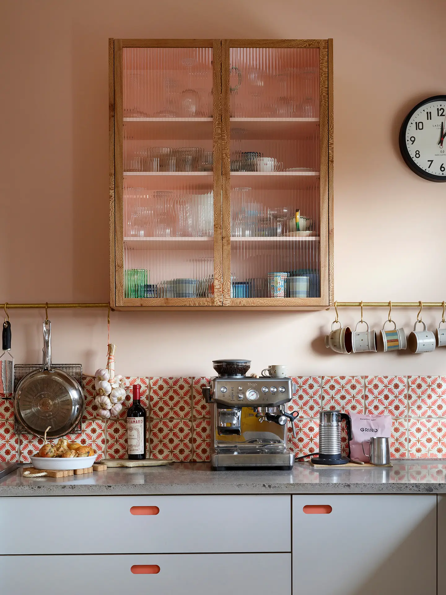 Fluted glass cabinet in a pink, yellow and grey open plan Pluck kitchen in a family home on the Isle of Skye with spectacular views.