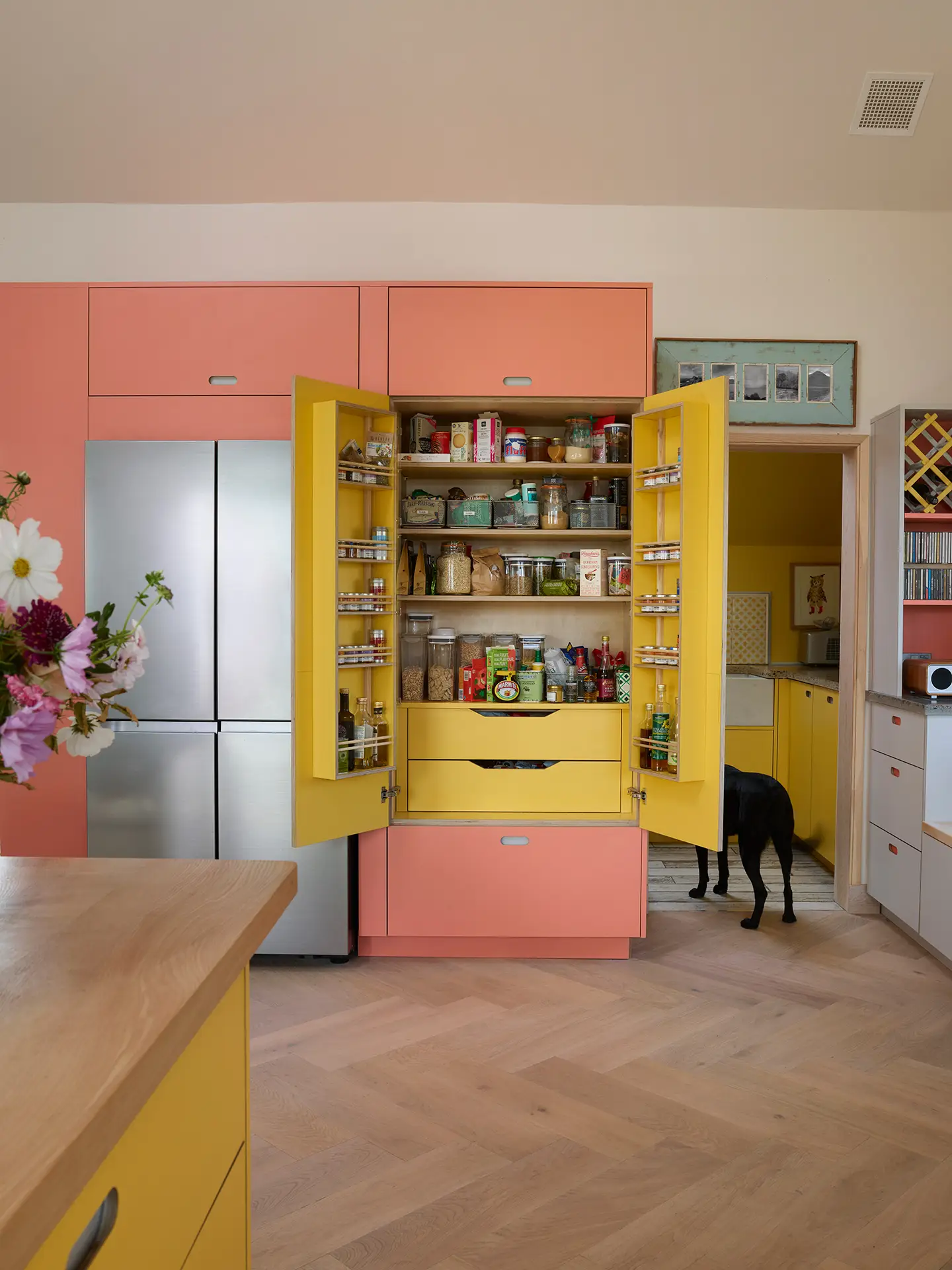 Pink, yellow and grey open plan Pluck kitchen in a family home in the Isle of Skye.