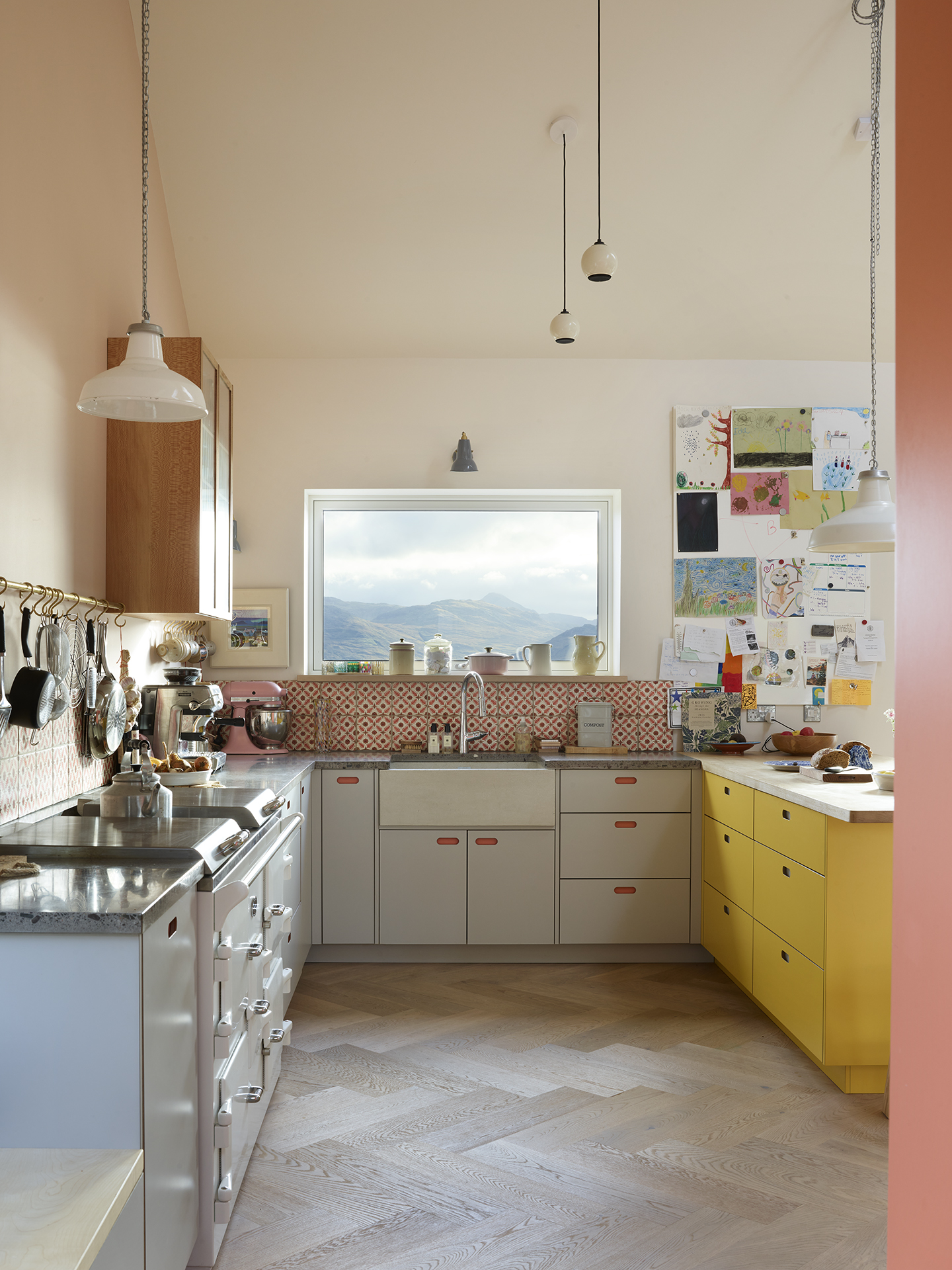 Pink, yellow and grey open plan Pluck kitchen in a family home on the Isle of Skye with spectacular views.