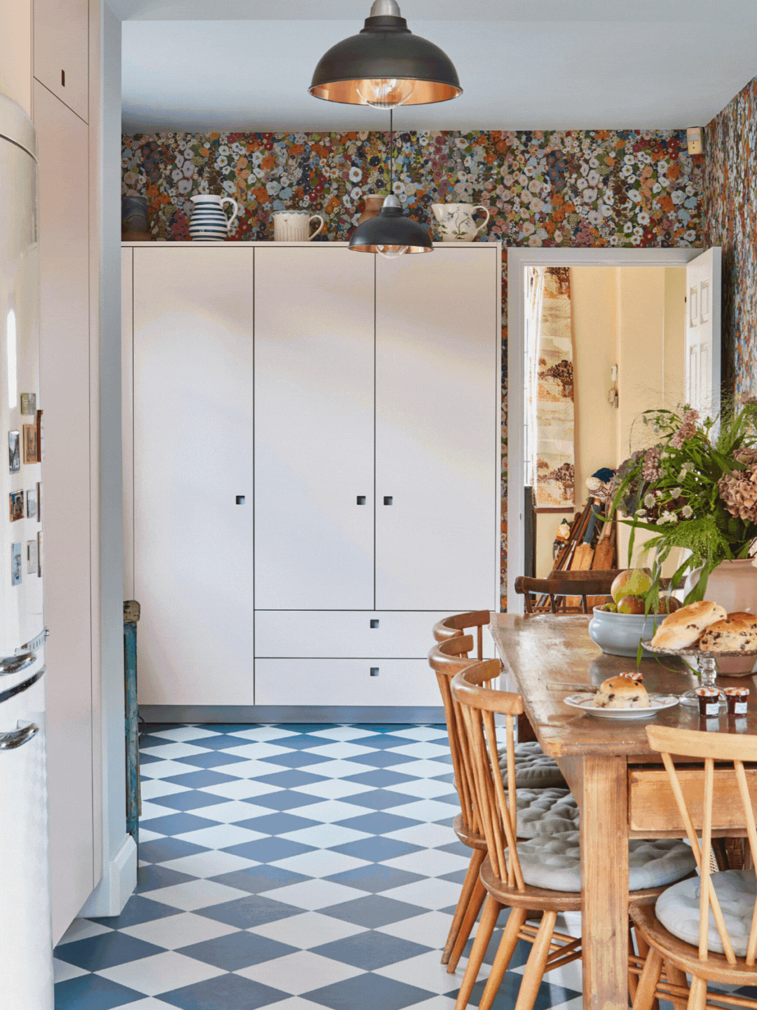 Pluck Kitchens Larder Cupboard 01 Pale pink and dark blue Pluck larder in a cosy cottage with floral wallpaper and chequered floor.
