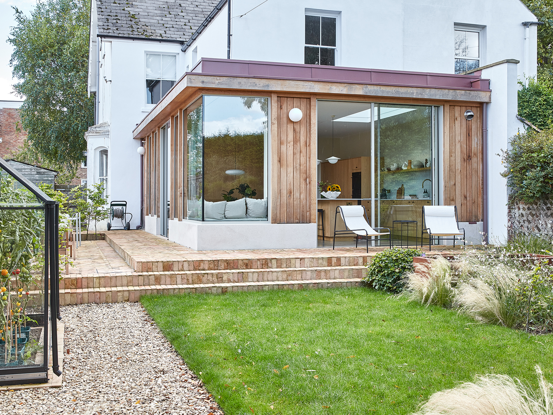 The exterior of a home with an open plan family kitchen with concrete floors.