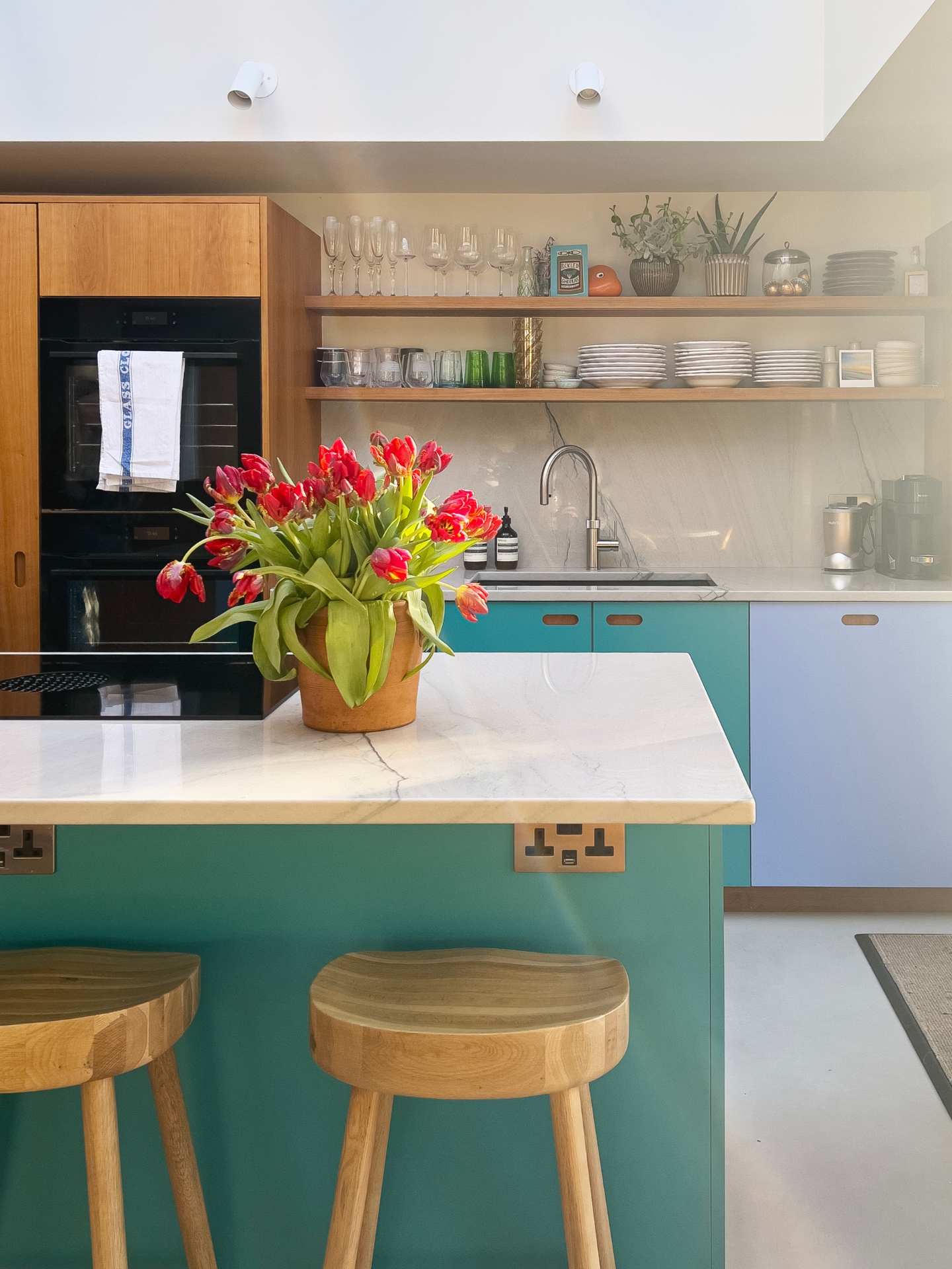 Shades of blue and Cherry wood Pluck cabinetry topped with swirling natural stone marble in a Grade II listed Victorian townhouse.
