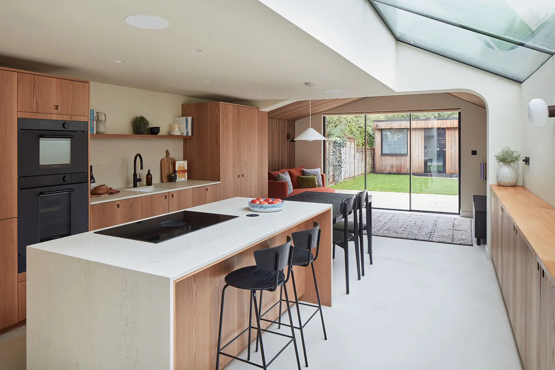 Elm wood family kitchen with a waterfall edge island for keen cooks and custom shallow cabinets for children's toys and crafts.