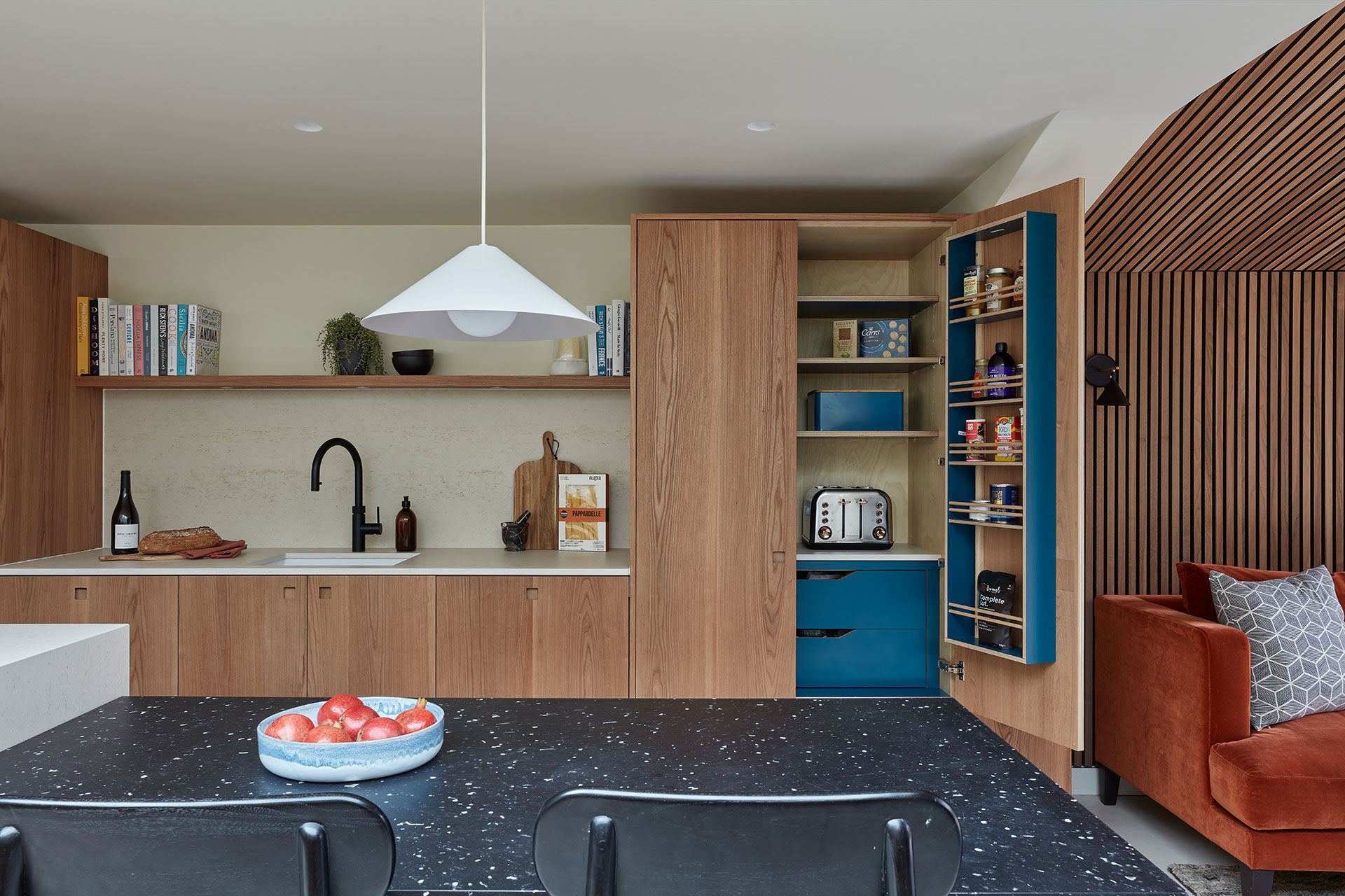Warm Elm wood Pluck cabinetry including an island and larder in an open plan Nunhead home.