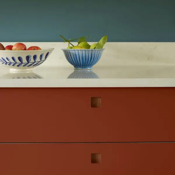 Pluck-The-Essex-Kitchen-with-Earthy-Tones-11 Moody hues of a kitchen in Essex with orange and red two tone cabinetry and a navy blue wall.