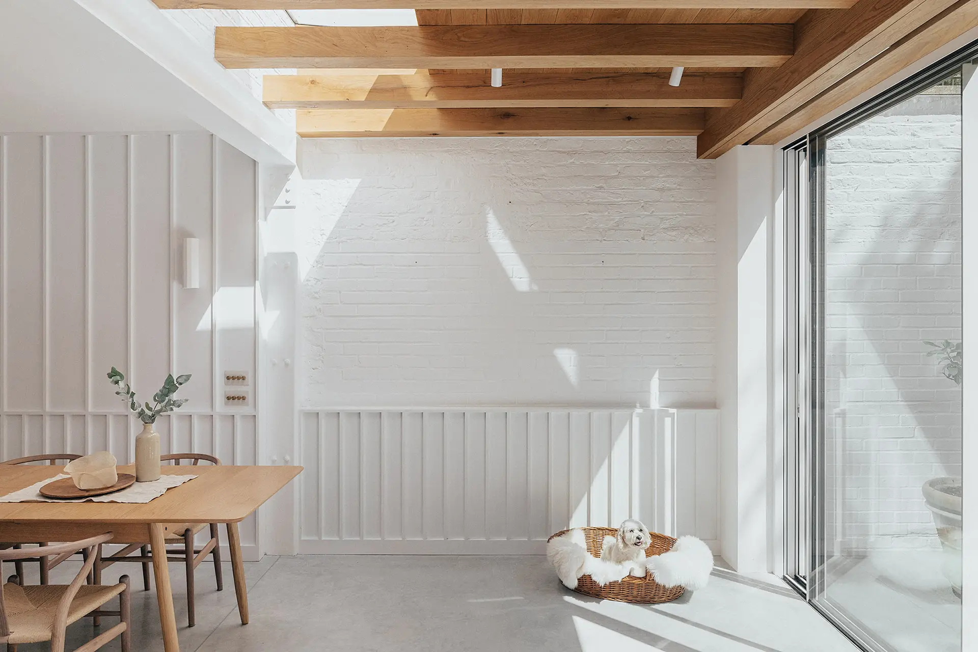 Victorian townhouse with white kitchen cabinetry, exposed oak beams and polished concrete flooring.