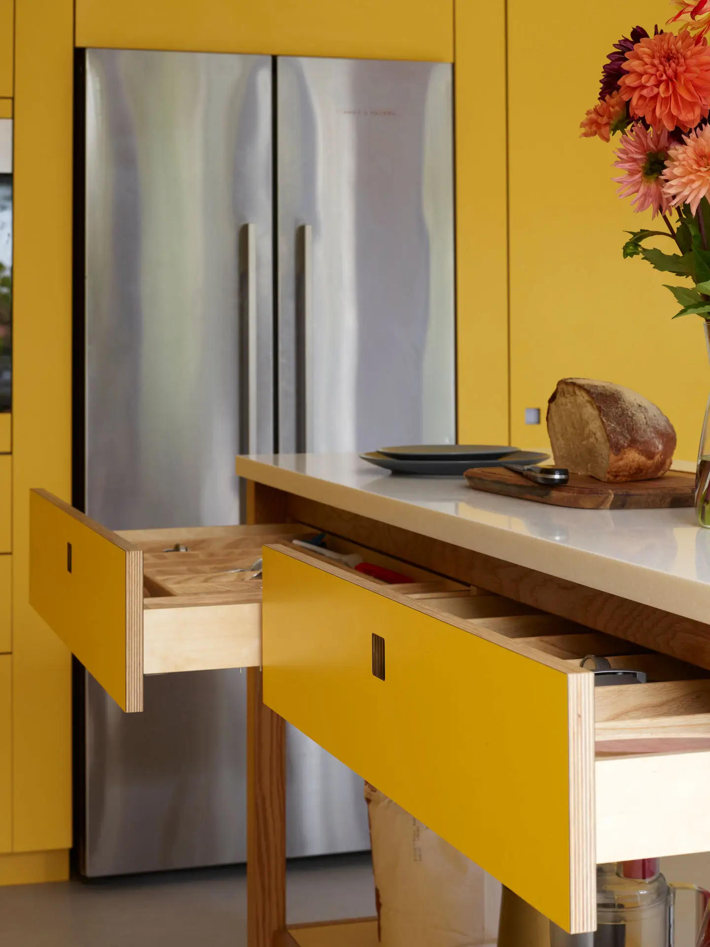 Yellow Pluck kitchen cabinetry with an Oak wood framed prep table including drawers and storing baking kit.