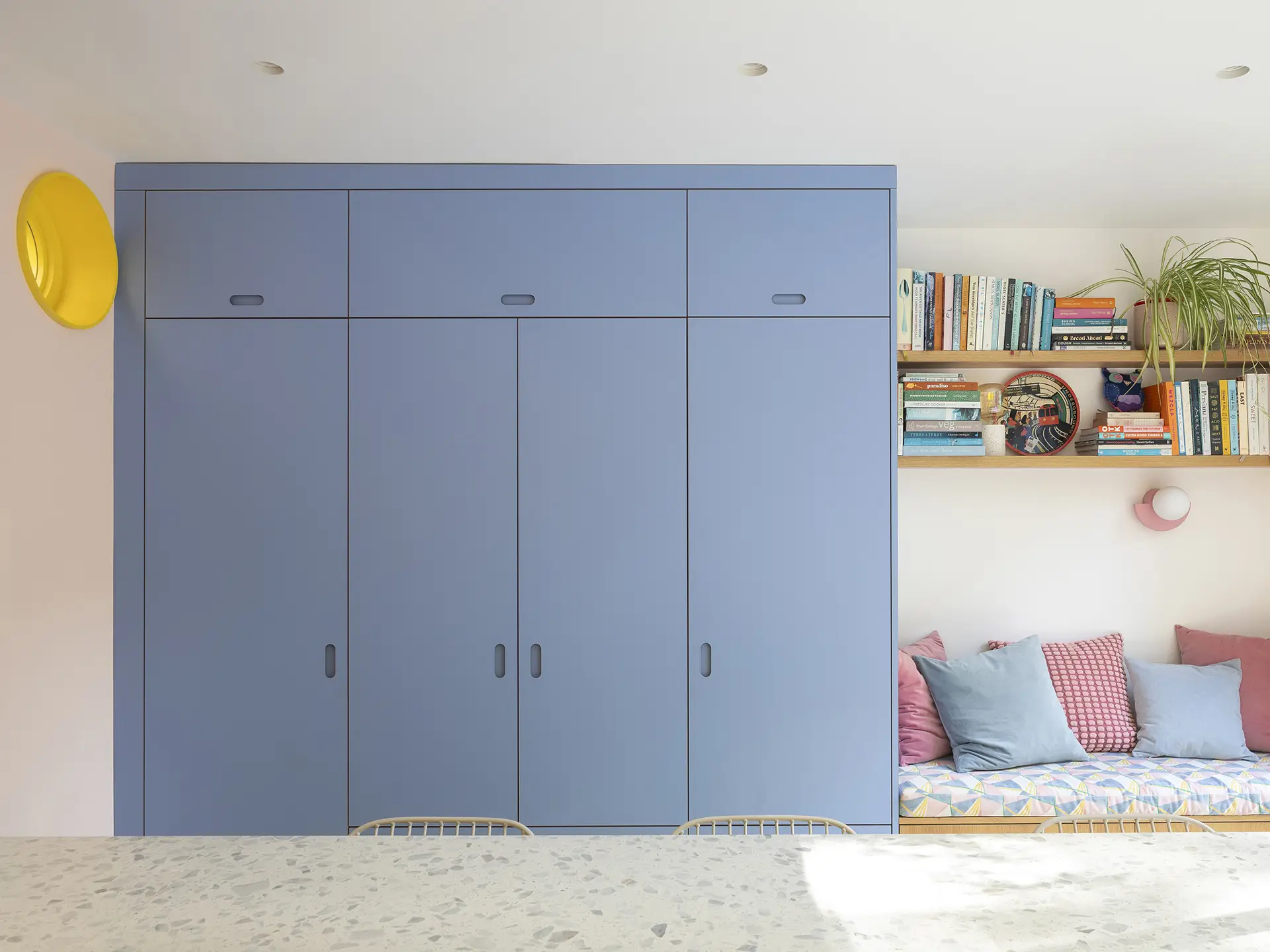 Colourful open plan Pluck kitchen with curves and a terrazzo topped island and floor tiles.