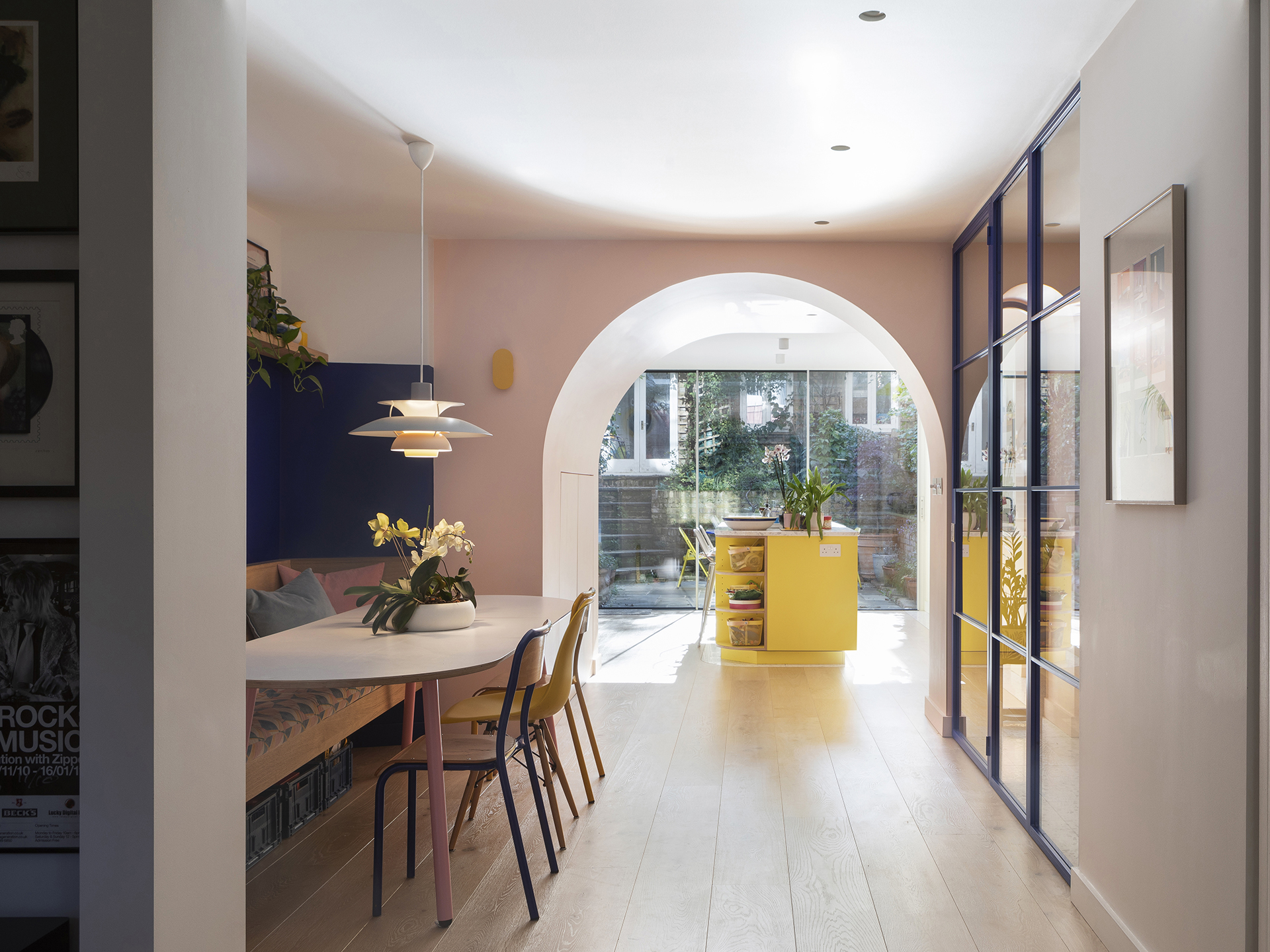 Colourful open plan Pluck kitchen with curves and a terrazzo topped island and floor tiles.
