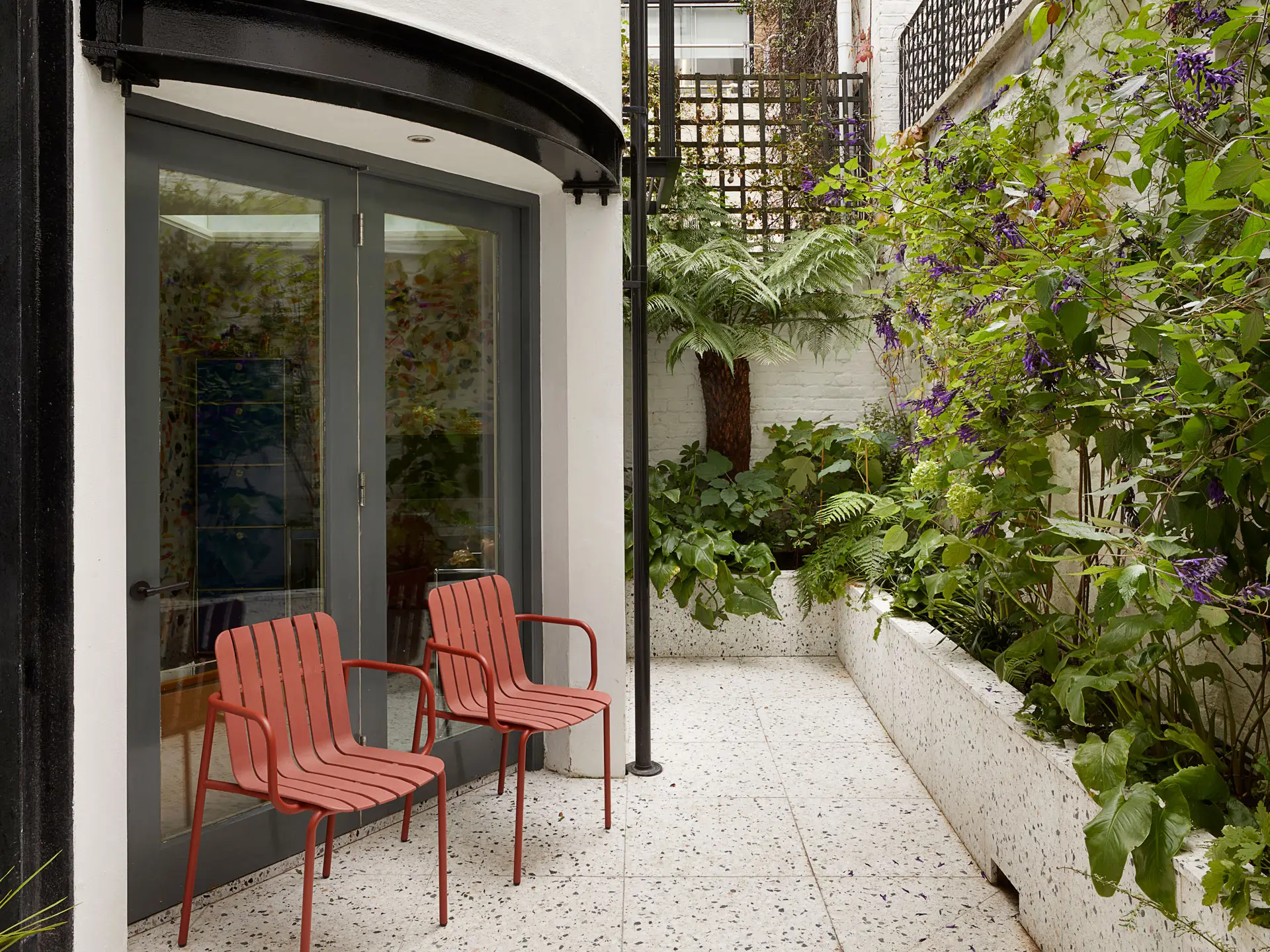 The courtyard of a Westminster townhouse with a blue, mustard yellow and wood Pluck kitchen.