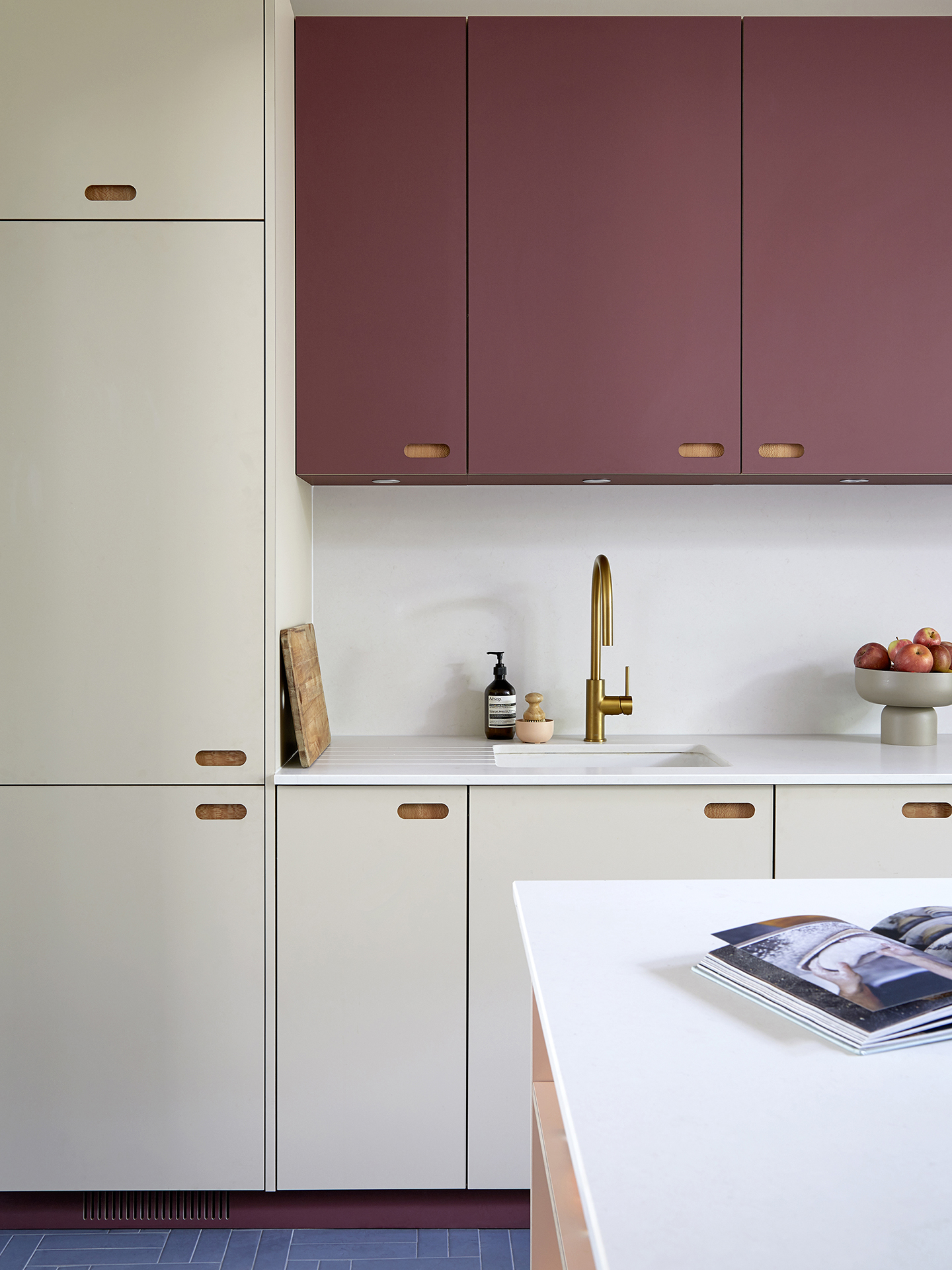 Soft, matt eco colours in a family kitchen including raspberry pink and oat coloured linen cupboards.