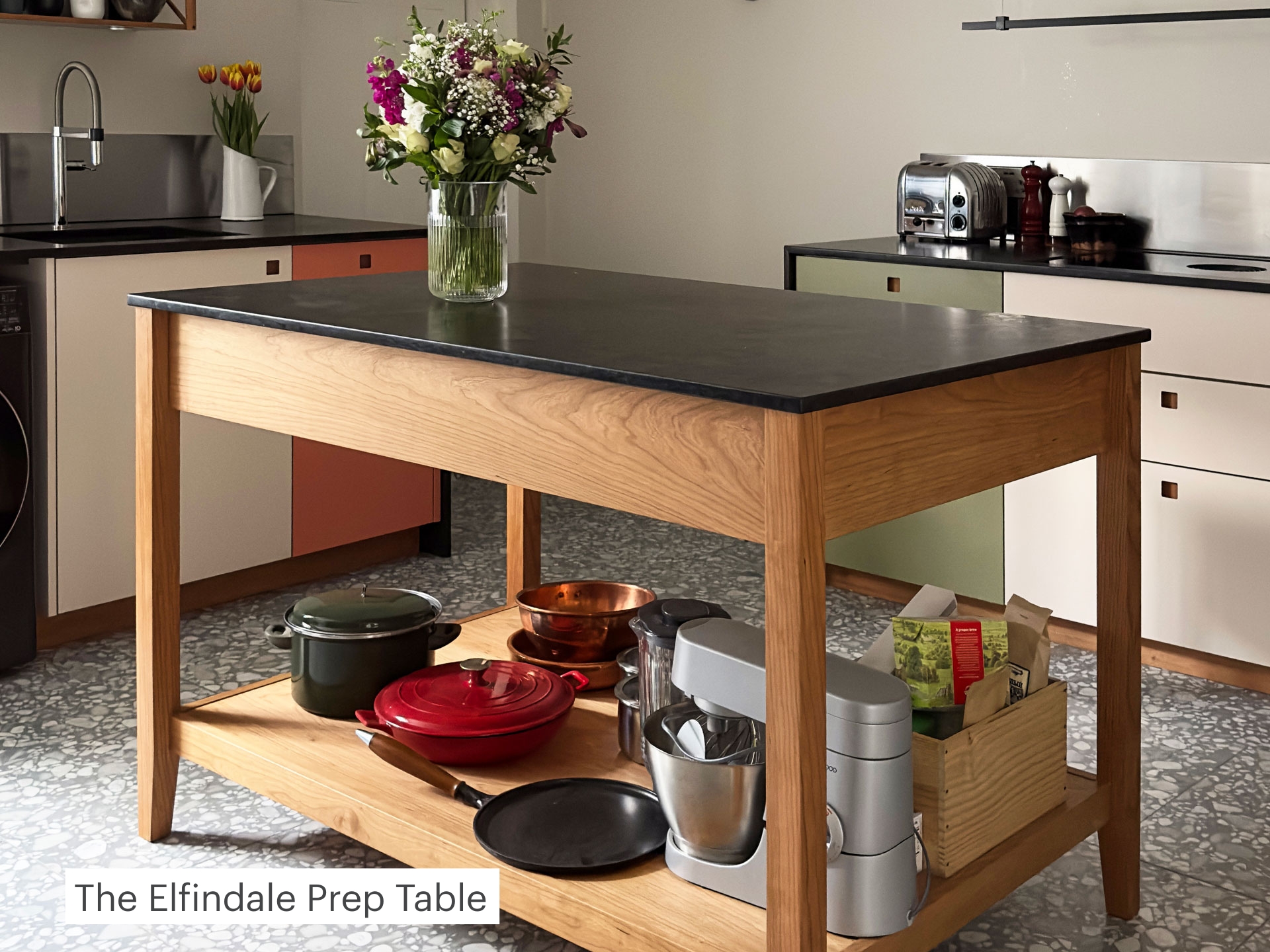 Kitchen prep table with timber legs and a stone top.