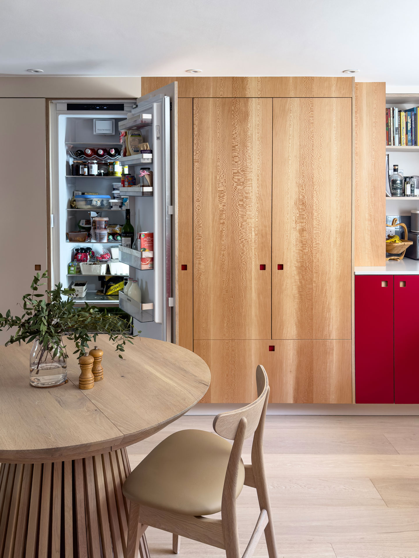 A u-shaped family kitchen in London with Pluck's Regent Red, London Plane wood and Eccles cabinets and a range cooker.