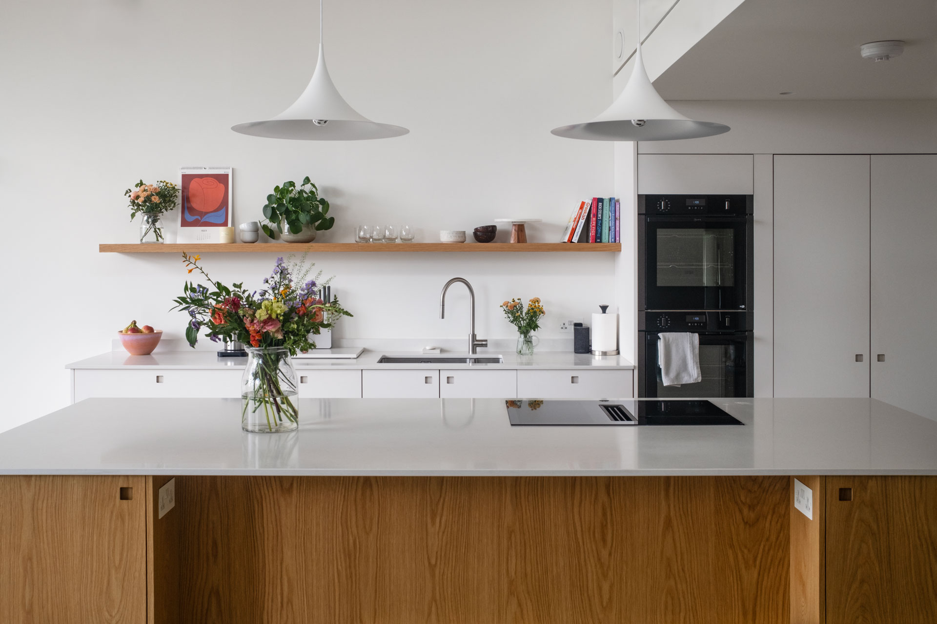 White and Oak wood custom cabinetry in a Pluck kitchen with an island and larder in Cheltenham.