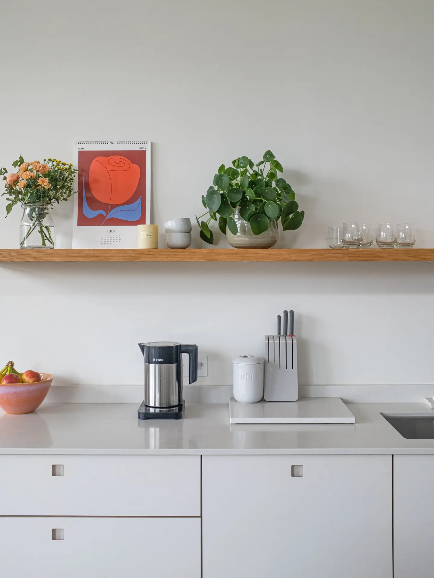 A white and wood open plan Pluck kitchen in a newly built family home on the edge of the Cotswolds.