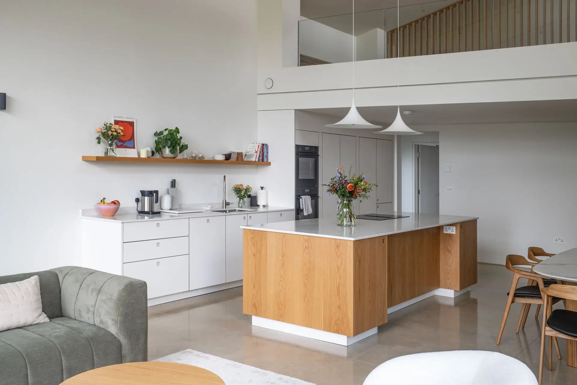 A white and wood open plan Pluck kitchen in a newly built family home on the edge of the Cotswolds.