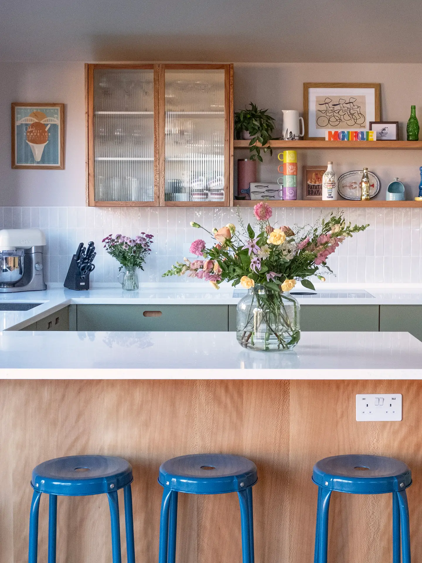 Kitchen wall cabinet with glass doors and wooden shelves.