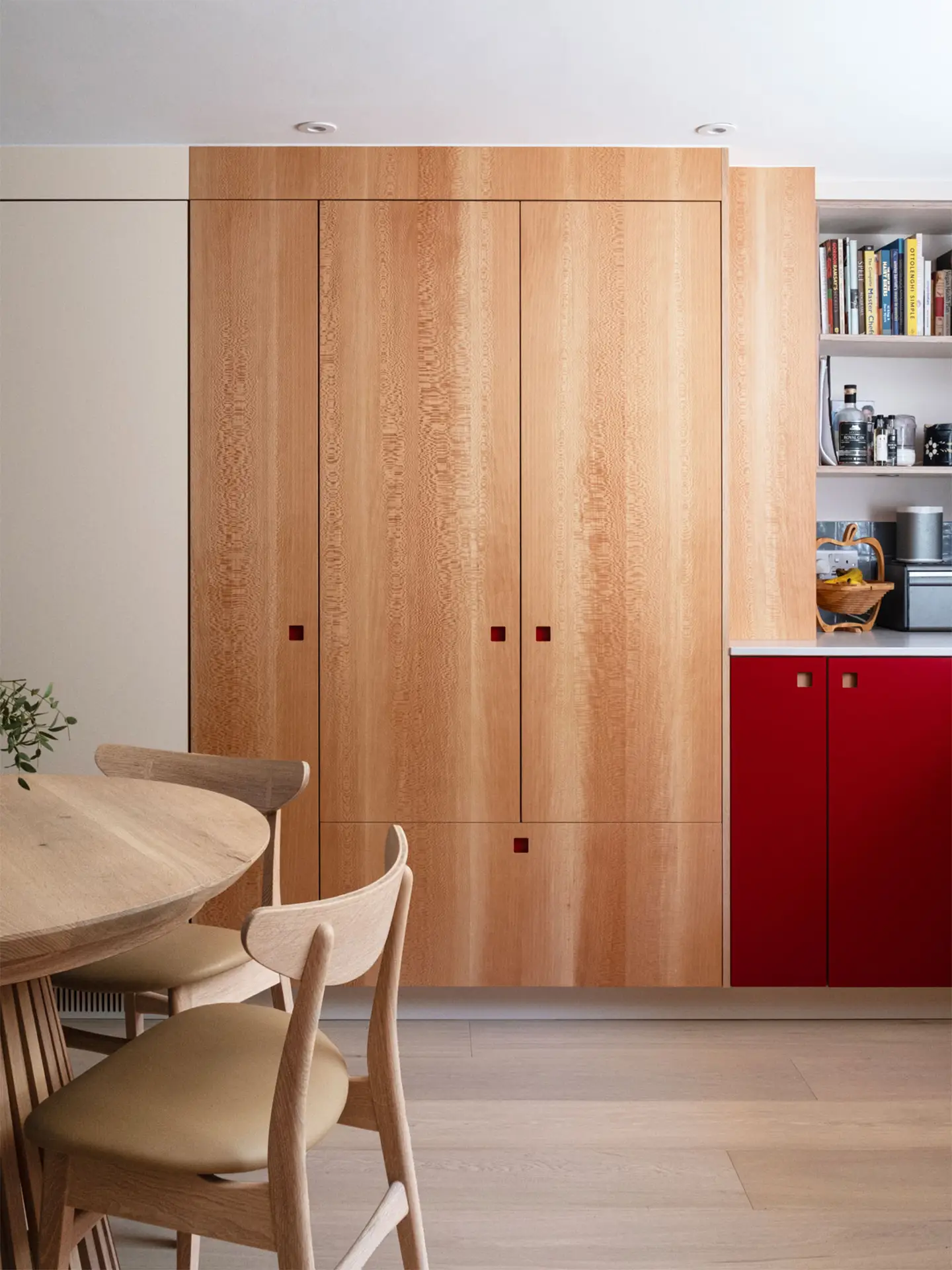 Bright kitchen with london plane cabinets and a wooden table with chairs.