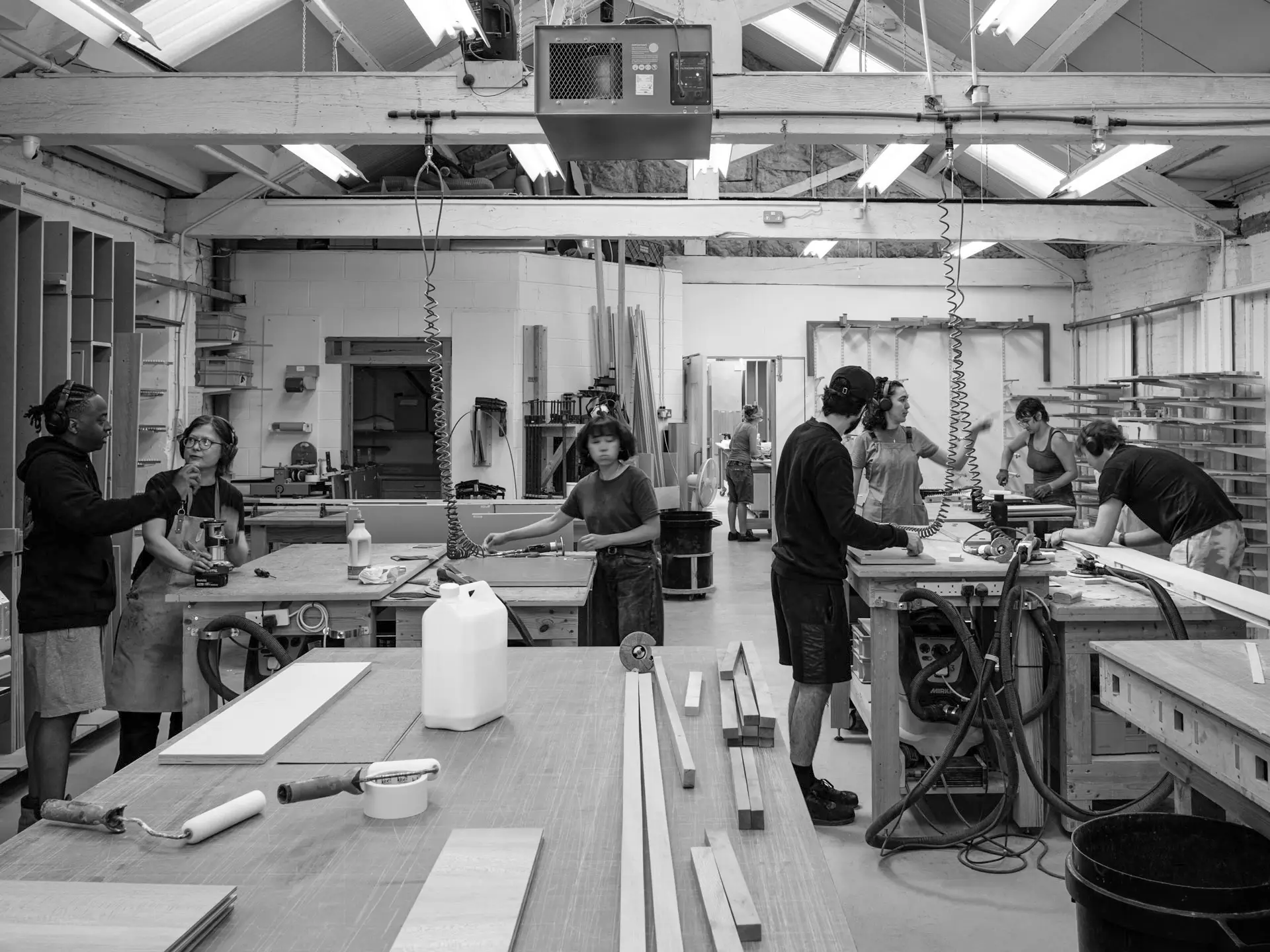 Pluck-London-Workshop-02a Busy workshop scene with numerous workbenches and cabinetmakers.
