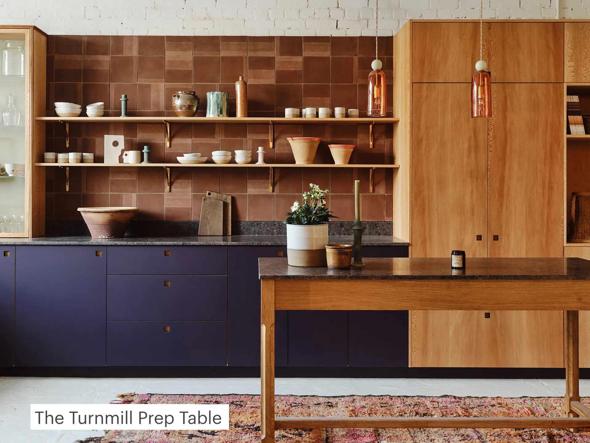 Kitchen prep table with timber legs and a stone top.