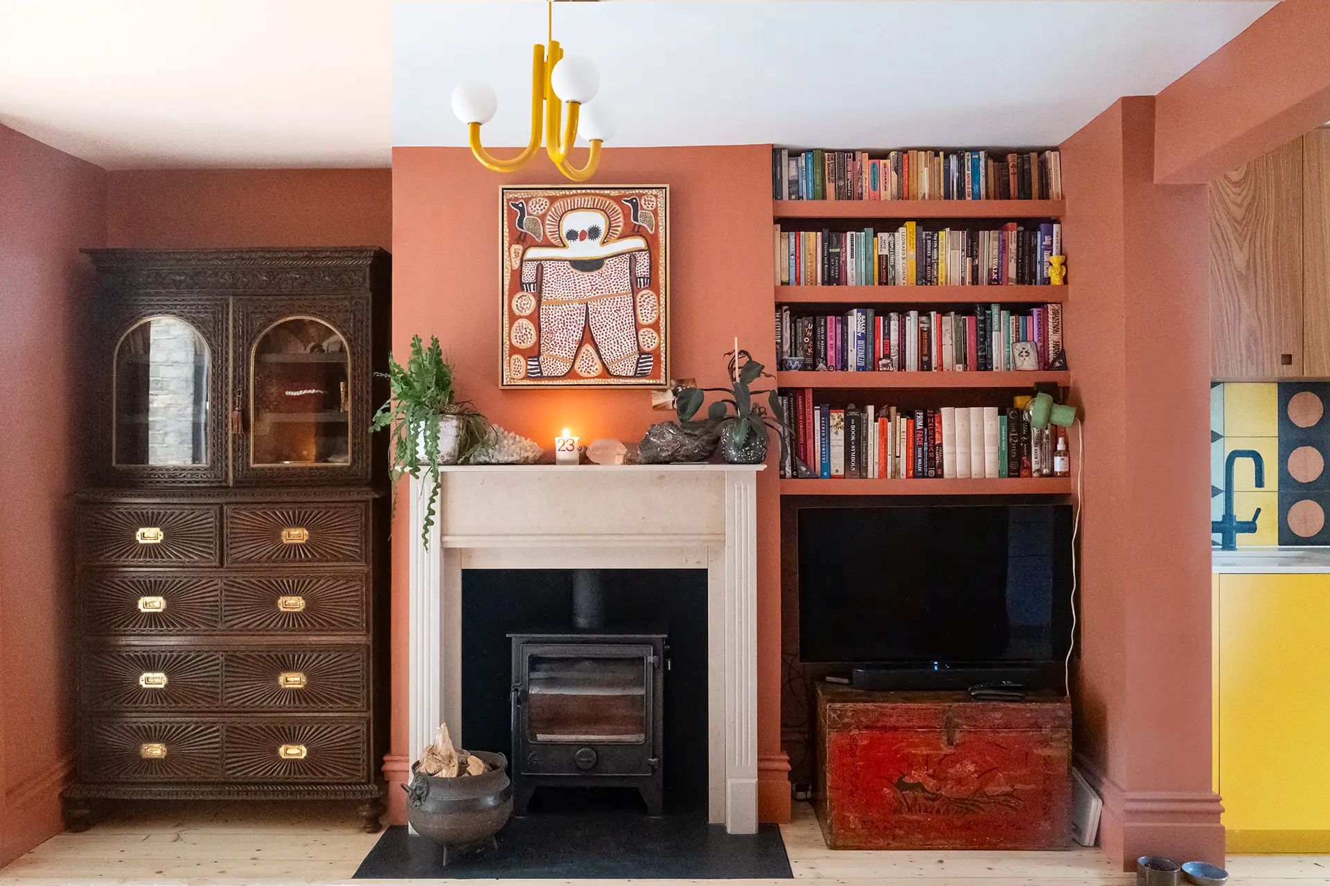 A family kitchen in Greenwich with colourful cabinetry, wooden floors, patterned tiles and antique table.