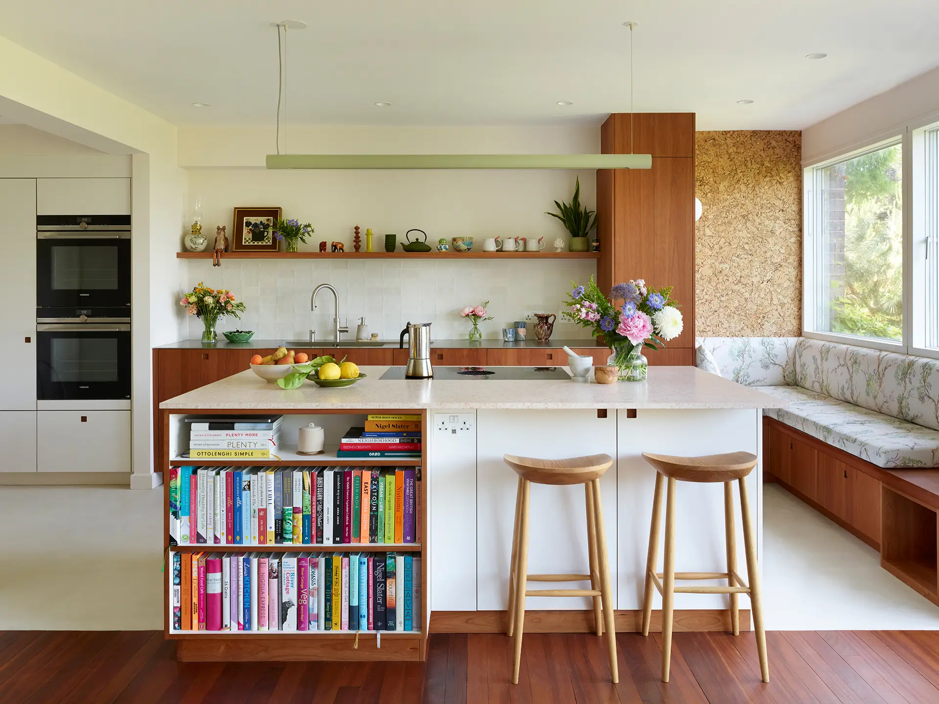 Pluck kitchen with white and cherry wood cabinetry, a large island sits in the centre of the room.